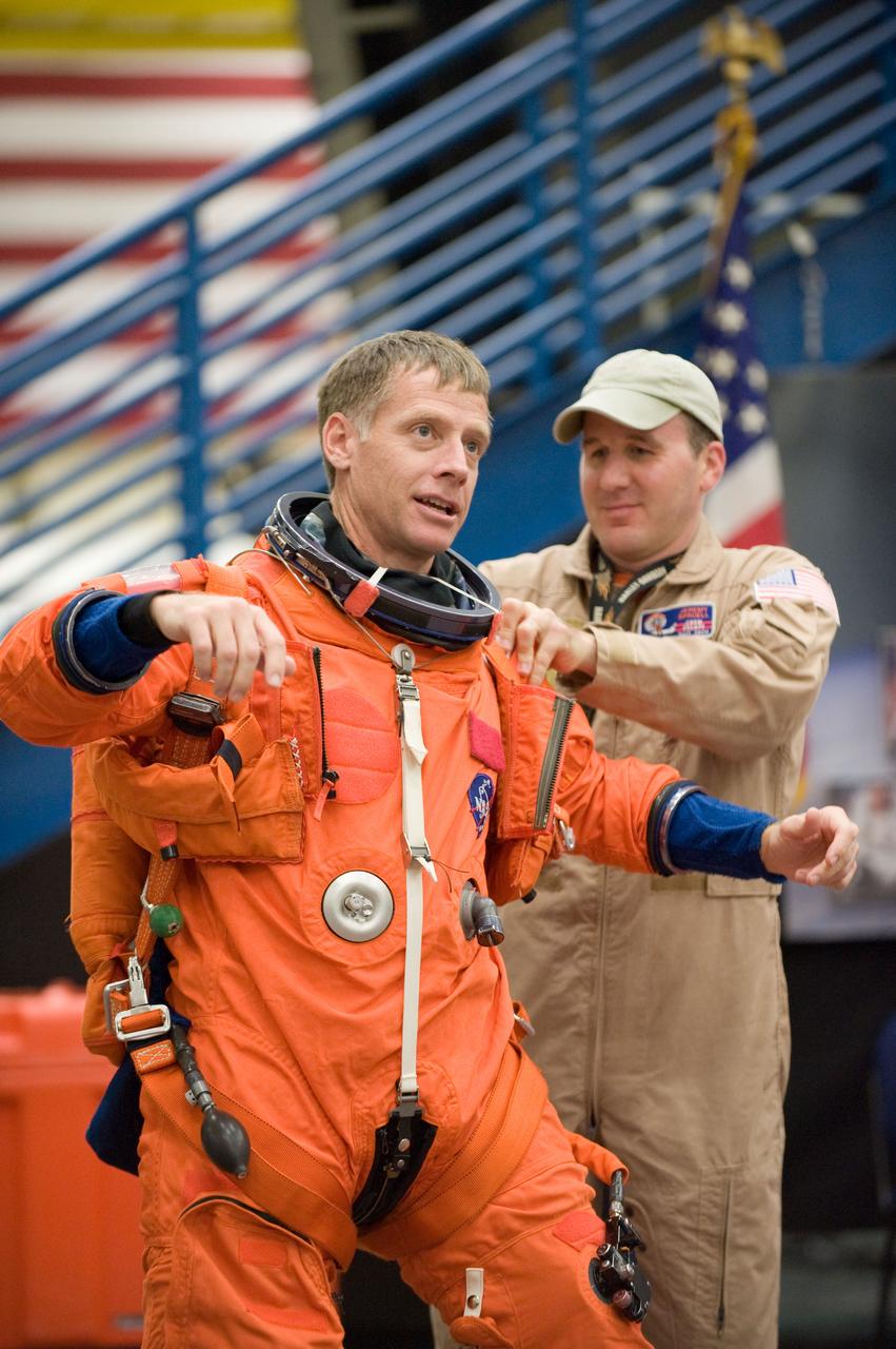 JSC2010-E-195523 (3 Dec. 2010) --- NASA astronaut Chris Ferguson, STS-135 commander, dons a training version of his shuttle launch and entry suit in preparation for an emergency egress training session in the Space Vehicle Mock-up Facility at NASA's Johnson Space Center. United Space Alliance suit technician Jeremy Spruell assisted Ferguson. STS-135 is planned to be the final mission of the space shuttle program. Photo credit: NASA or National Aeronautics and Space Administration