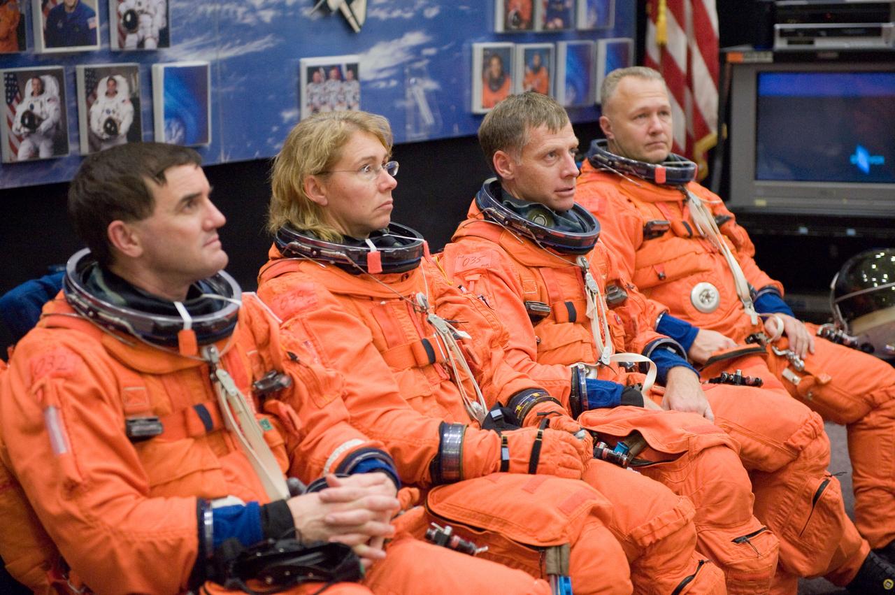 JSC2010-E-195547 (3 Dec. 2010) --- Attired in training versions of their shuttle launch and entry suits, STS-135 crew members listen to a briefing by a crew instructor (out of frame) in preparation for a training session in the Space Vehicle Mock-up Facility at NASA's Johnson Space Center. Pictured from the left are NASA astronauts Rex Walheim, Sandy Magnus, both mission specialists; Chris Ferguson, commander; and Doug Hurley, pilot. STS-135 is planned to be the final mission of the space shuttle program. Photo credit: NASA or National Aeronautics and Space Administration