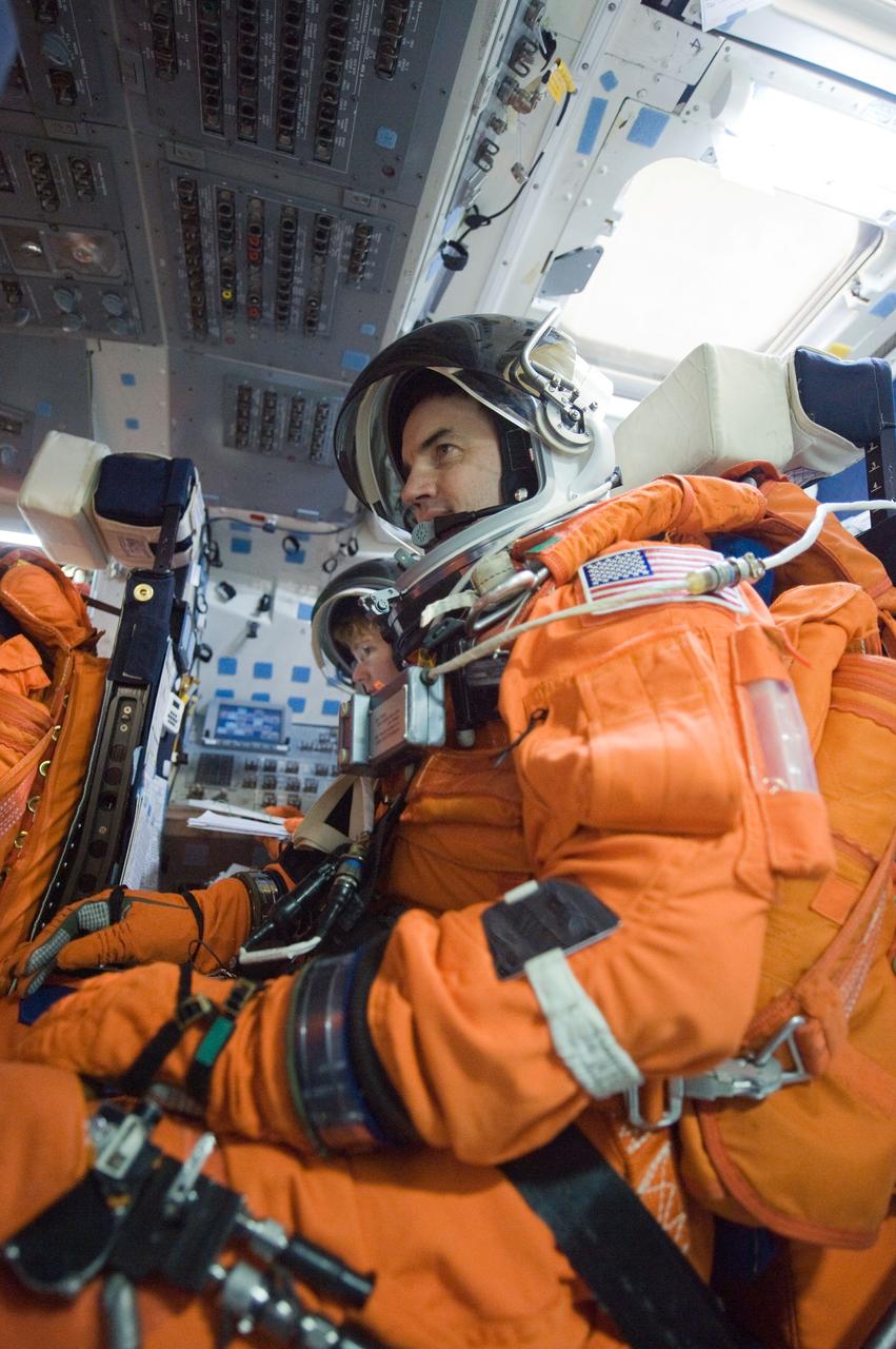 JSC2010-E-196891 (20 Dec. 2010) --- NASA astronauts Rex Walheim and Sandy Magnus (mostly obscured), both STS-135 mission specialists, attired in training versions of their shuttle launch and entry suits, participate in a post insertion/de-orbit training session on the flight deck of the crew compartment trainer (CCT-2) in the Space Vehicle Mockup Facility at NASA's Johnson Space Center. STS-135 is planned to be the final mission of the space shuttle program. Photo credit: NASA or National Aeronautics and Space Administration