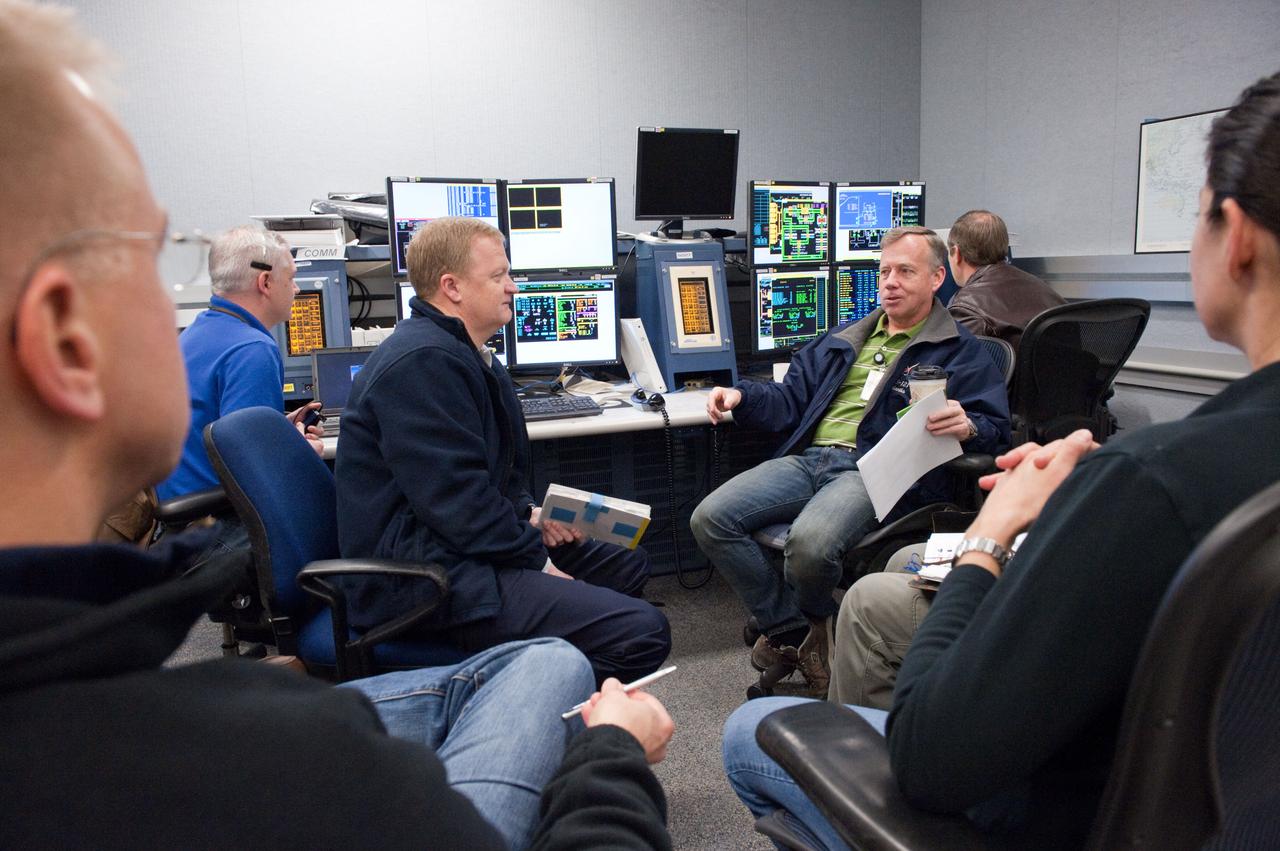JSC2011-E-003039 (14 Jan. 2011) --- STS-133 crew members participate in a training session in the fixed-base shuttle mission simulator (SMS) and the Space Station Training Facility (SSTF) in the Jake Garn Simulation and Training Facility at NASA's Johnson Space Center. Pictured are NASA astronauts Steve Lindsey (right background), commander; Eric Boe (left background), pilot; Tim Kopra and Nicole Stott (partially out of frame in the foreground), both mission specialists. Photo credit: NASA or National Aeronautics and Space Administration