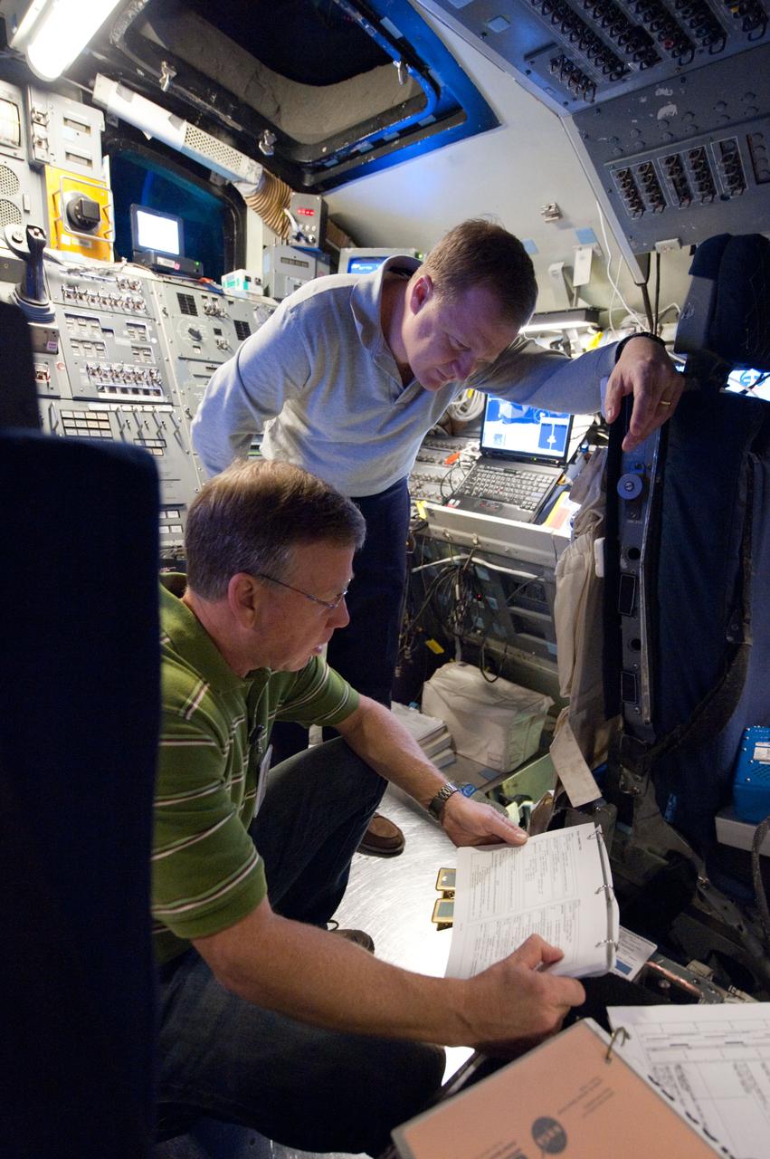 JSC2011-E-003046 (14 Jan. 2011) --- NASA astronauts Steve Lindsey (foreground), STS-133 commander; and Eric Boe, pilot, participate in a training session in the fixed-base shuttle mission simulator (SMS) in the Jake Garn Simulation and Training Facility at NASA's Johnson Space Center. Photo credit: NASA or National Aeronautics and Space Administration