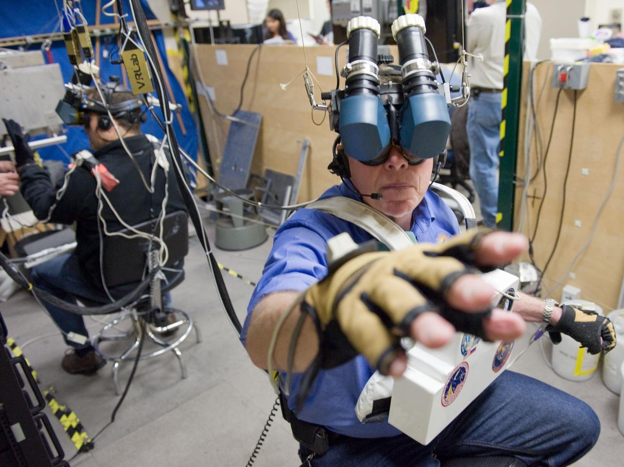 JSC2011-E-003210 (18 Jan. 2011) --- NASA astronaut Mike Fossum, Expedition 28 flight engineer and Expedition 29 commander, uses virtual reality hardware in the Space Vehicle Mock-up Facility at NASA's Johnson Space Center to rehearse some of his duties on the upcoming mission to the International Space Station. This type of virtual reality training allows the astronauts to wear a helmet and special gloves while looking at computer displays simulating actual movements around the various locations on the station hardware with which they will be working. Photo credit: NASA or National Aeronautics and Space Administration