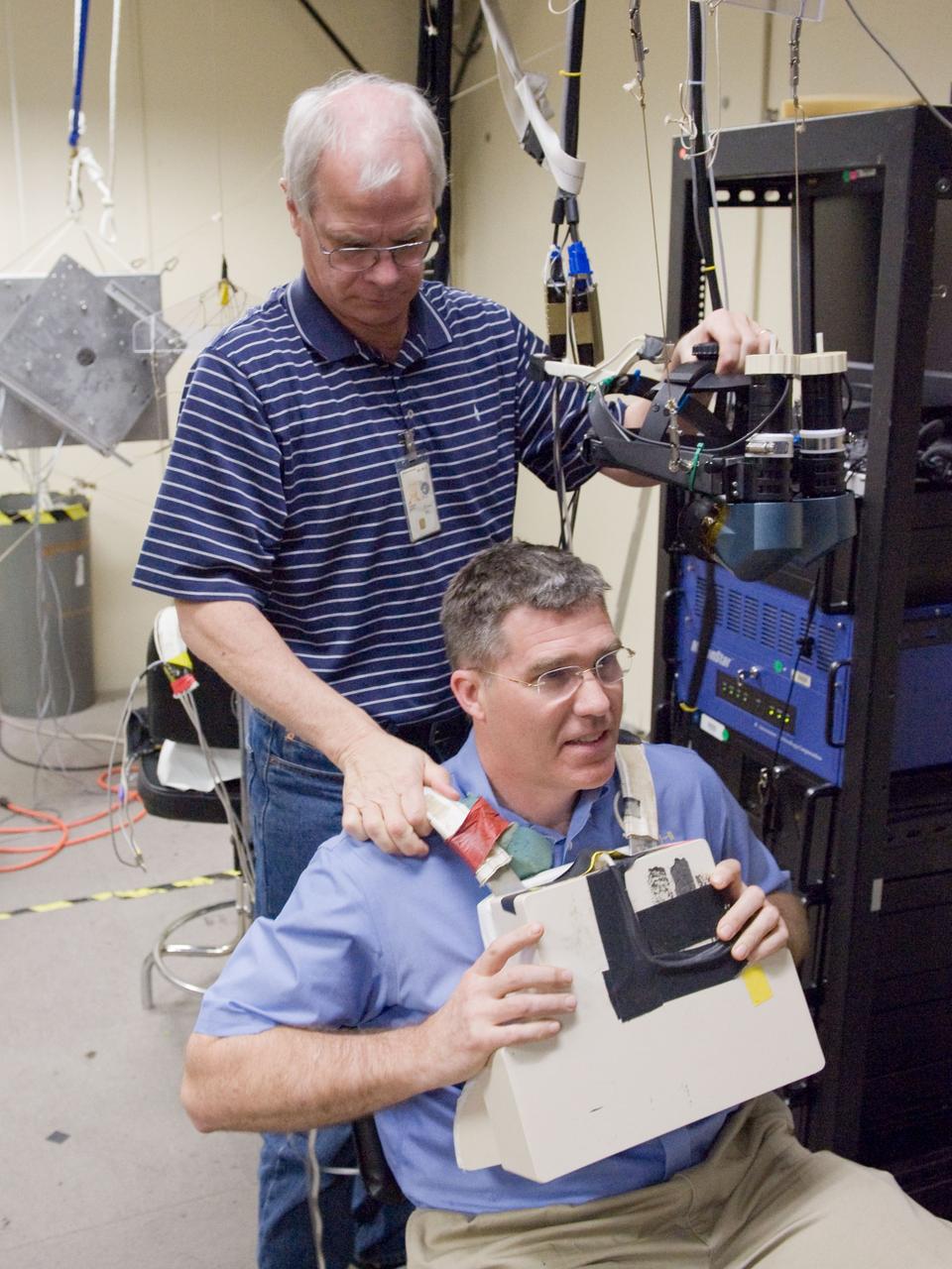 JSC2011-E-006294 (24 Jan. 2011) --- NASA astronaut Steve Bowen, STS-133 mission specialist, uses virtual reality hardware in the Space Vehicle Mock-up Facility at NASA's Johnson Space Center to rehearse some of his duties on the upcoming mission to the International Space Station. This type of virtual reality training allows the astronauts to wear a helmet and special gloves while looking at computer displays simulating actual movements around the various locations on the station hardware with which they will be working. Crew trainer David Homan assisted Bowen. Photo credit: NASA or National Aeronautics and Space Administration