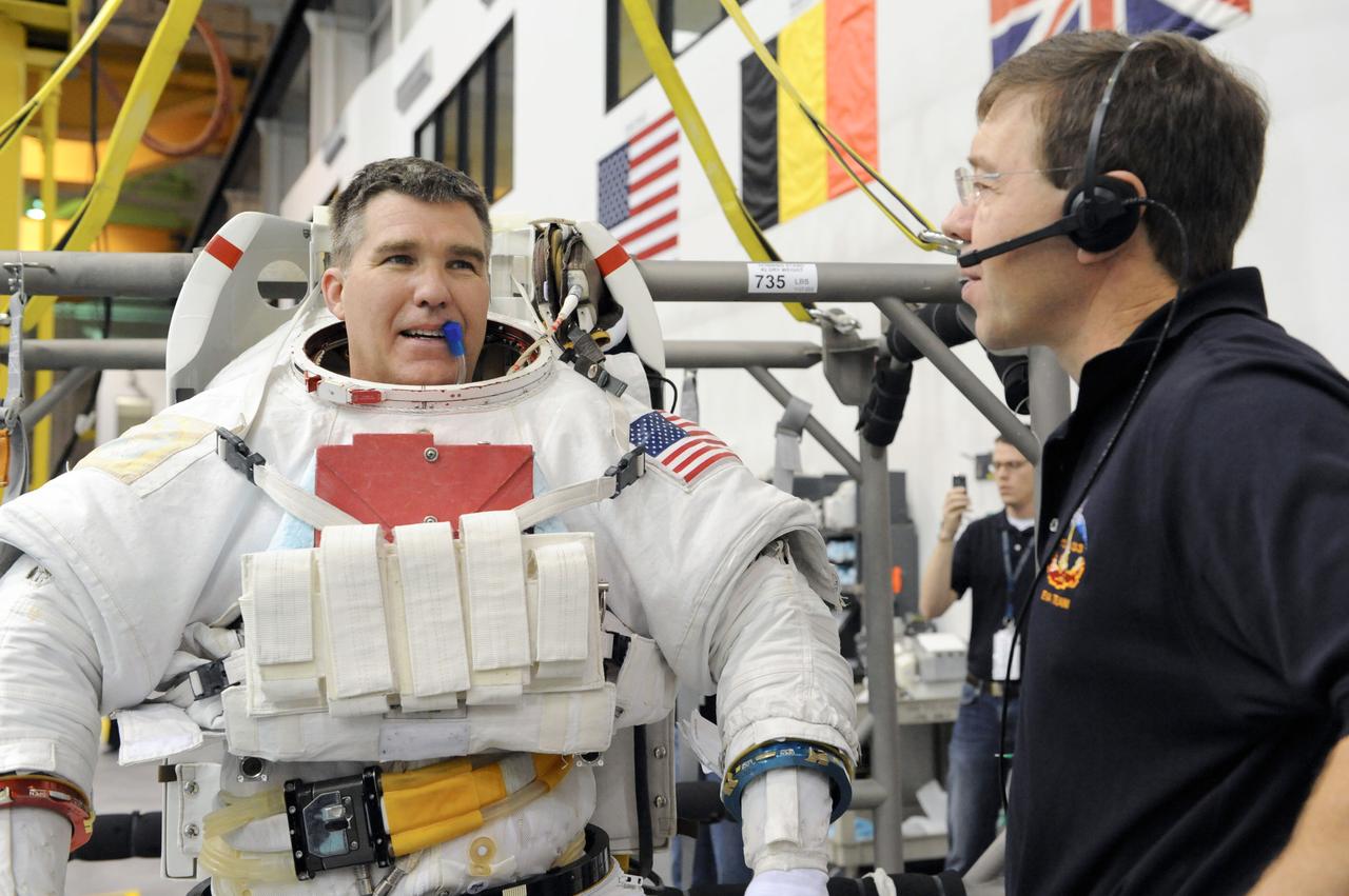 JSC2011-E-013869 (28 Jan. 2011) --- NASA astronaut Steve Bowen, STS-133 mission specialist, attired in a training version of his Extravehicular Mobility Unit (EMU) spacesuit, prepares for the start of a spacewalk training session in the waters of the Neutral Buoyancy Laboratory (NBL) near NASA's Johnson Space Center. NASA astronaut Michael Barratt, mission specialist, assisted Bowen. Photo credit: NASA or National Aeronautics and Space Administration