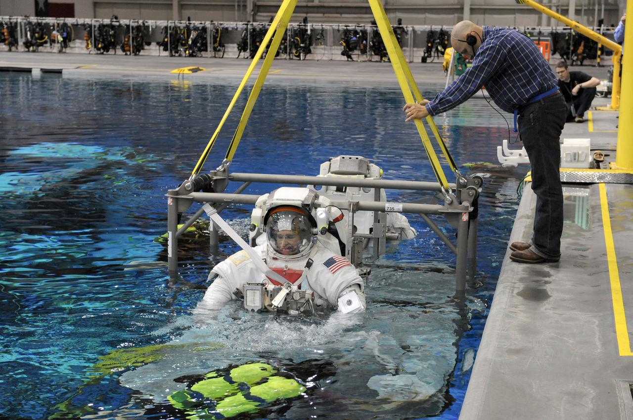 JSC2011-E-013877 (28 Jan. 2011) --- NASA astronauts Steve Bowen (foreground) and Alvin Drew, both STS-133 mission specialists, attired in training versions of their Extravehicular Mobility Unit (EMU) spacesuits, are submerged in the waters of the Neutral Buoyancy Laboratory (NBL) near NASA's Johnson Space Center. Divers are in the water to assist Bowen and Drew in their rehearsal, which is intended to help prepare them for work on the exterior of the International Space Station. Photo credit: NASA or National Aeronautics and Space Administration