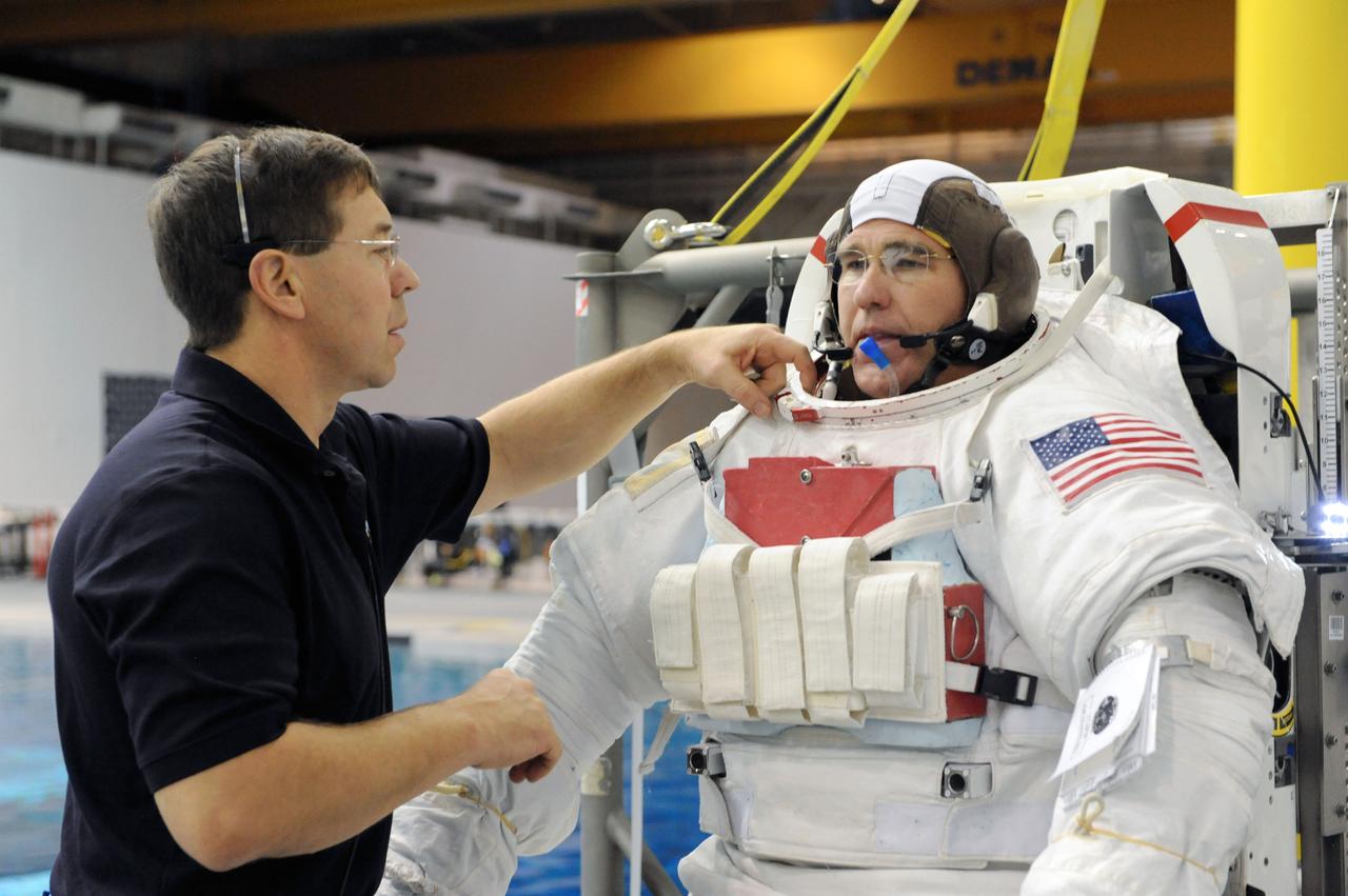 JSC2011-E-013887 (28 Jan. 2011) --- NASA astronaut Steve Bowen, STS-133 mission specialist, attired in a training version of his Extravehicular Mobility Unit (EMU) spacesuit, prepares for the start of a spacewalk training session in the waters of the Neutral Buoyancy Laboratory (NBL) near NASA's Johnson Space Center. NASA astronaut Michael Barratt, mission specialist, assisted Bowen. Photo credit: NASA or National Aeronautics and Space Administration