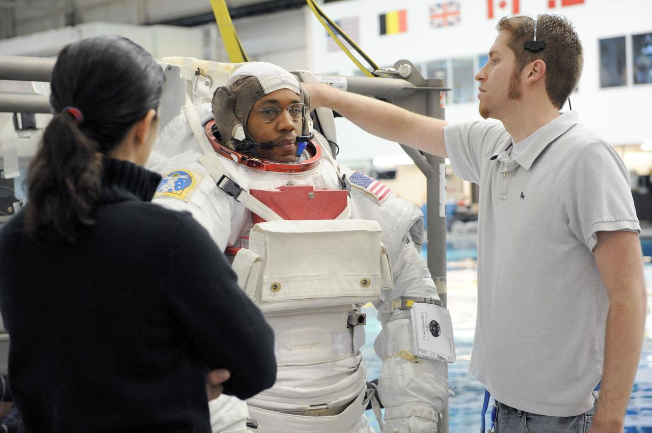 JSC2011-E-013893 (28 Jan. 2011) --- NASA astronaut Alvin Drew, STS-133 mission specialist, gets help donning a training version of his Extravehicular Mobility Unit (EMU) spacesuit in preparation for a spacewalk training session in the waters of the Neutral Buoyancy Laboratory (NBL) near NASA's Johnson Space Center. NASA astronaut Nicole Stott, mission specialist, assisted Drew. Photo credit: NASA or National Aeronautics and Space Administration