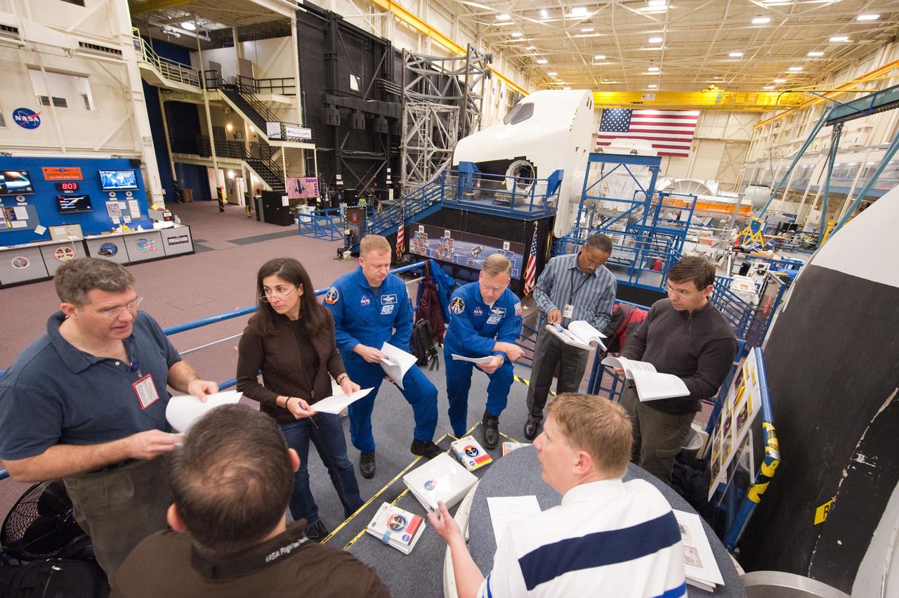 JSC2011-E-013949 (1 Feb. 2011) --- STS-133 crew members participate in a photo/TV training session in the Space Vehicle Mock-up Facility at NASA's Johnson Space Center. Pictured from the left are NASA astronauts Steve Bowen, Nicole Stott, both mission specialists; Eric Boe, pilot; Steve Lindsey, commander; Alvin Drew and Michael Barratt, both mission specialists. Crew trainer Gary Kilgo (right foreground) assisted the crew members. Photo credit: NASA or National Aeronautics and Space Administration