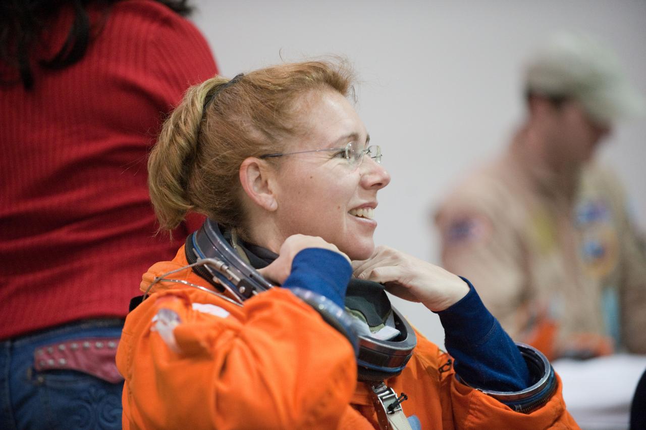 JSC2011-E-016224 (9 Feb. 2011) --- NASA astronaut Sandy Magnus, STS-135 mission specialist, dons a training version of her shuttle launch and entry suit in preparation for a water survival training session in the Neutral Buoyancy Laboratory (NBL) near NASA's Johnson Space Center. STS-135 is planned to be the final mission of the space shuttle program. Photo credit: NASA or National Aeronautics and Space Administration