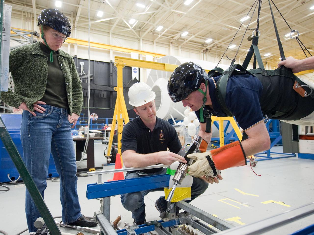 JSC2011-E-017413 (16 Feb. 2011) --- NASA astronaut Rex Walheim, STS-135 mission specialist, participates in an extravehicular activity (EVA) training session in the Partial Gravity Simulator (POGO) test area in the Space Vehicle Mock-up Facility at NASA's Johnson Space Center. NASA astronaut Sandy Magnus, mission specialist, looks on. Photo credit: NASA or National Aeronautics and Space Administration