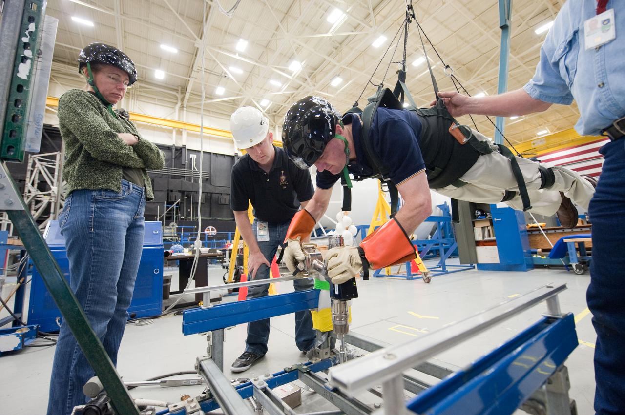 JSC2011-E-017417 (16 Feb. 2011) --- NASA astronaut Rex Walheim, STS-135 mission specialist, participates in an extravehicular activity (EVA) training session in the Partial Gravity Simulator (POGO) test area in the Space Vehicle Mock-up Facility at NASA's Johnson Space Center. NASA astronaut Sandy Magnus, mission specialist, looks on. Photo credit: NASA or National Aeronautics and Space Administration