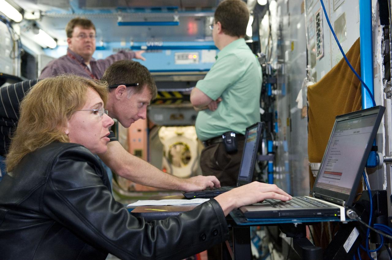 JSC2011-E-021706 (25 Feb. 2011) --- NASA astronaut Chris Ferguson, STS-135 commander; and Sandy Magnus, mission specialist, use computers during a training session in a space station mock-up in the Space Vehicle Mock-up Facility at NASA's Johnson Space Center. Photo credit: NASA or National Aeronautics and Space Administration