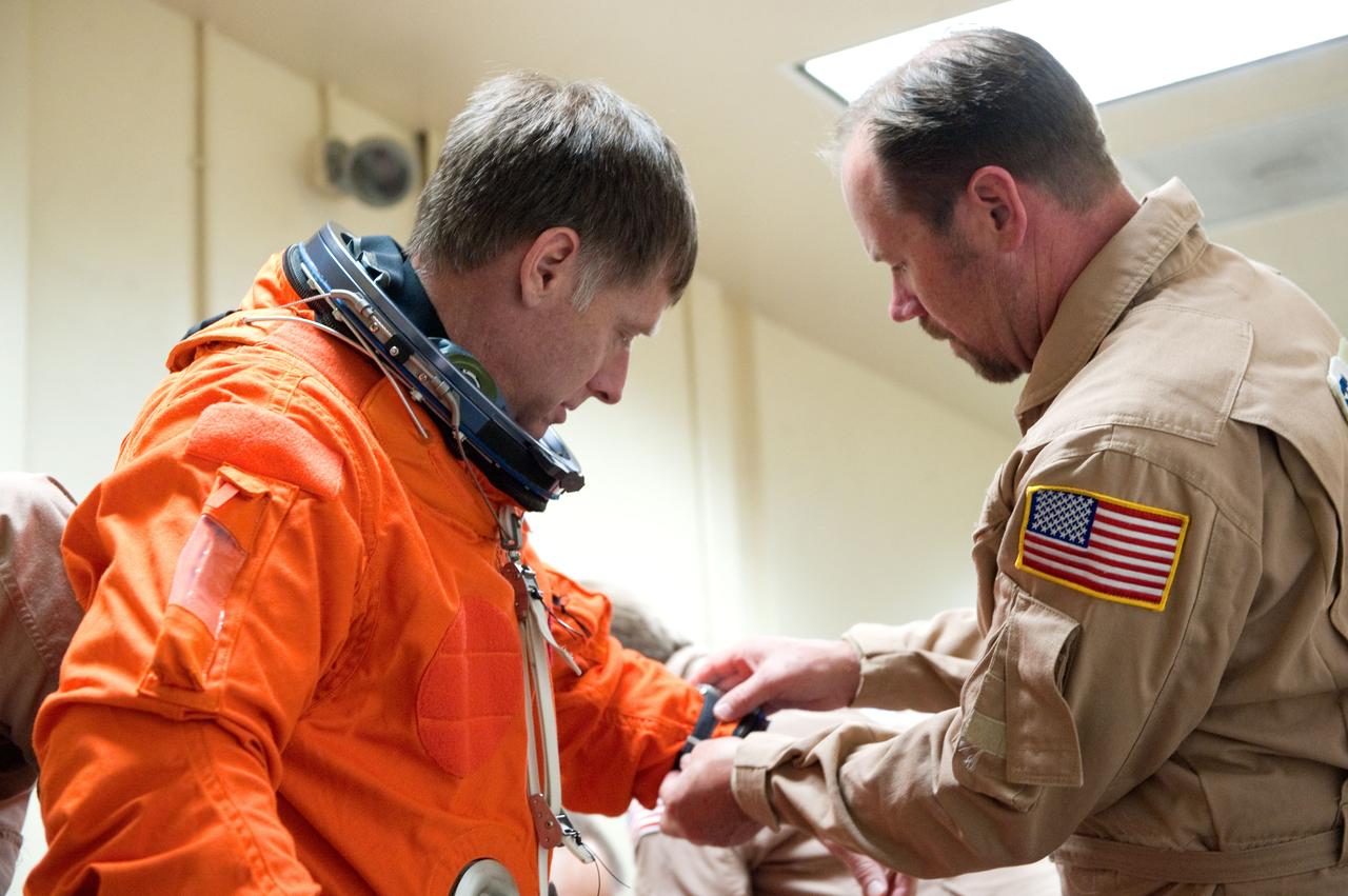 JSC2011-E-023113 (2 March 2011) --- NASA astronaut Chris Ferguson, STS-135 commander, dons a training version of his shuttle launch and entry suit in preparation for a training session in the fixed-base shuttle mission simulator (SMS) in the Jake Garn Simulation and Training Facility at NASA's Johnson Space Center. Suit technician Drew Billingsley assisted Ferguson. Photo credit: NASA or National Aeronautics and Space Administration
