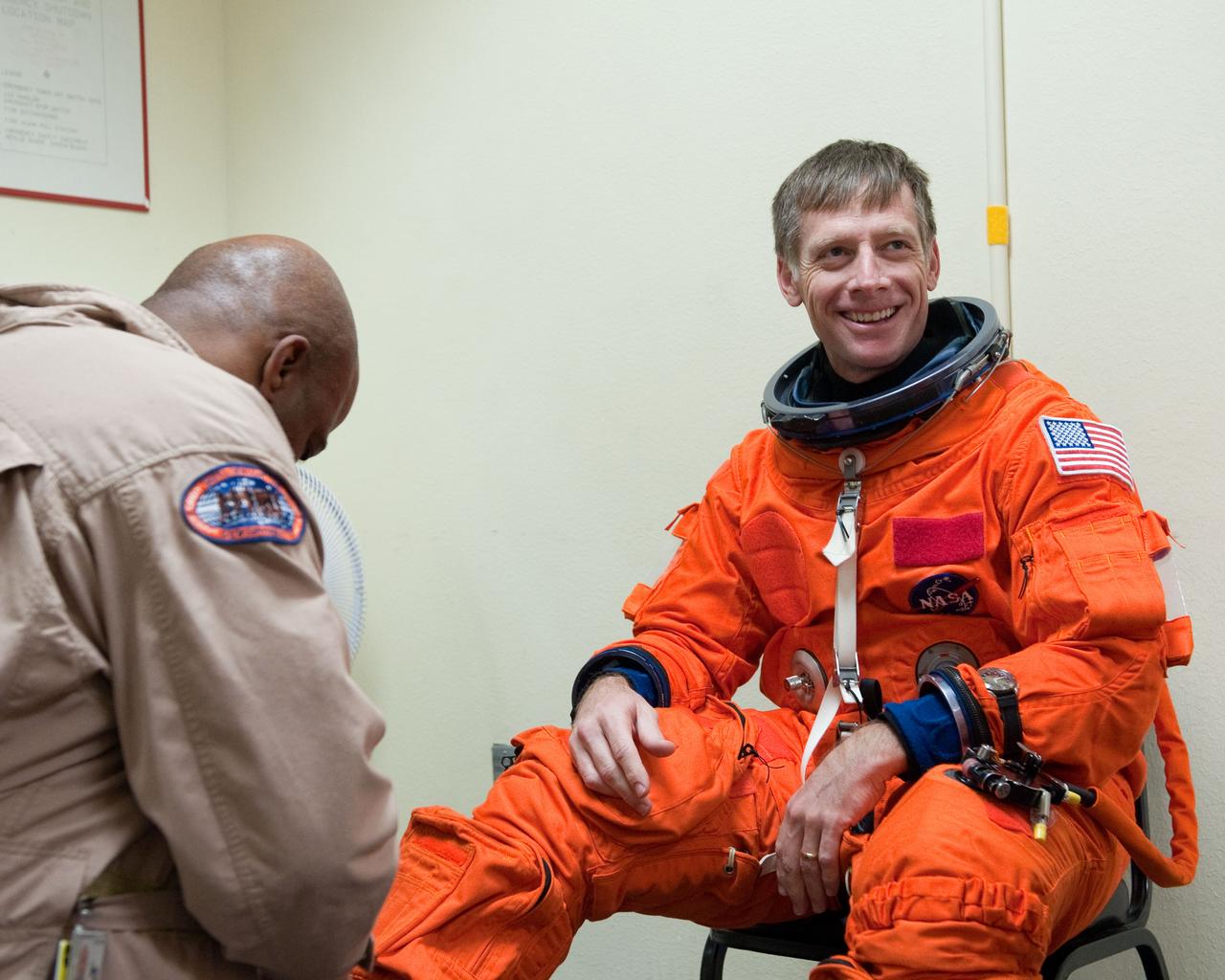 JSC2011-E-023114 (2 March 2011) --- NASA astronaut Chris Ferguson, STS-135 commander, dons a training version of his shuttle launch and entry suit in preparation for a training session in the fixed-base shuttle mission simulator (SMS) in the Jake Garn Simulation and Training Facility at NASA's Johnson Space Center. Suit technician Andre Denard assisted Ferguson. Photo credit: NASA or National Aeronautics and Space Administration