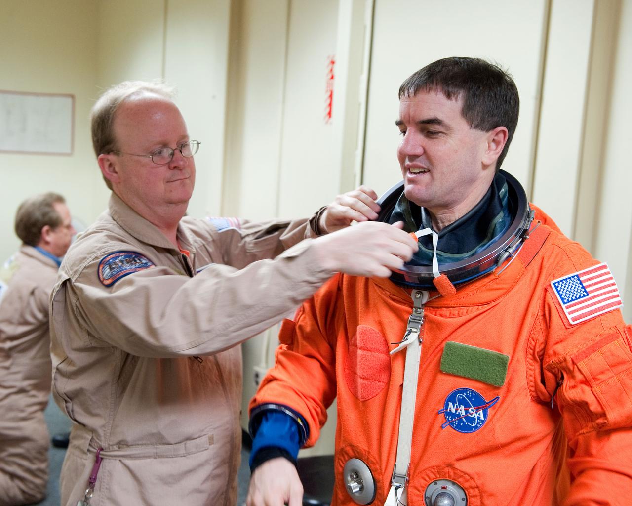 JSC2011-E-023118 (2 March 2011) --- NASA astronaut Rex Walheim, STS-135 mission specialist, dons a training version of his shuttle launch and entry suit in preparation for a training session in the fixed-base shuttle mission simulator (SMS) in the Jake Garn Simulation and Training Facility at NASA's Johnson Space Center. Suit technician Daniel Palmer assisted Walheim. Photo credit: NASA or National Aeronautics and Space Administration