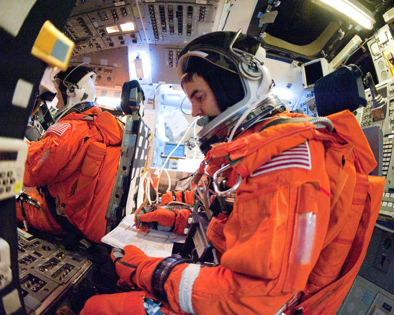 JSC2011-E-023121 (2 March 2011) --- NASA astronauts Rex Walheim, STS-135 mission specialist; and Doug Hurley (background), pilot, attired in training versions of their shuttle launch and entry suits, participate in a training session in the fixed-base shuttle mission simulator (SMS) in the Jake Garn Simulation and Training Facility at NASA's Johnson Space Center. Photo credit: NASA or National Aeronautics and Space Administration