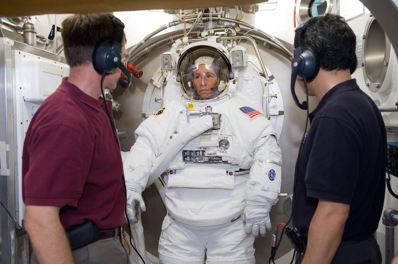JSC2011-E-024083 (4 March 2011) --- NASA astronaut Sandy Magnus, STS-135 mission specialist, participates in an Extravehicular Mobility Unit (EMU) spacesuit fit check in the Space Station Airlock Test Article (SSATA) in the Crew Systems Laboratory at NASA's Johnson Space Center. NASA astronaut Chris Ferguson (right), STS-135 commander; and Japan Aerospace Exploration Agency (JAXA) astronaut Satoshi Furukawa, Expedition 28/29 flight engineer, assisted Magnus. Photo credit: NASA or National Aeronautics and Space Administration