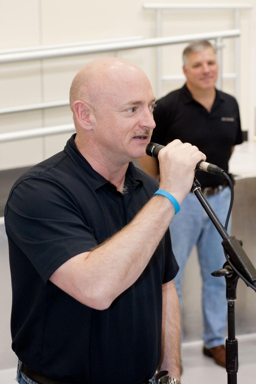 JSC2011-E-024817 (8 March 2011) --- NASA astronaut Mark Kelly, STS-134 commander, speaks to a crowd during a cake-cutting ceremony in the Jake Garn Simulation and Training Facility at NASA's Johnson Space Center. Also pictured in the background is NASA astronaut Greg H. Johnson, pilot. Photo credit: NASA or National Aeronautics and Space Administration