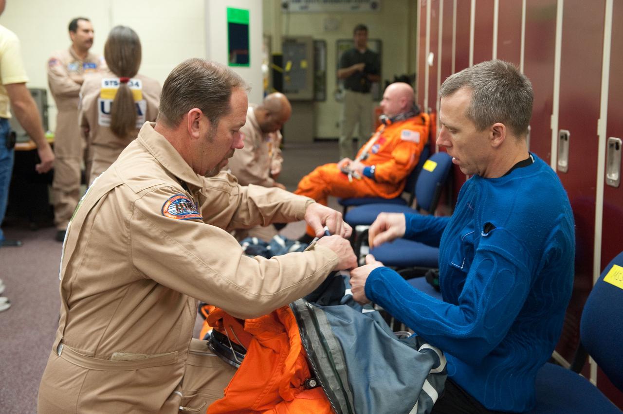 JSC2011-E-026913 (11 March 2011) --- NASA astronaut Andrew Feustel, STS-134 mission specialist, dons a training version of his shuttle launch and entry suit in preparation for an ingress/egress training session in a shuttle mock-up in the Space Vehicle Mock-up Facility at NASA's Johnson Space Center. Suit technician Drew Billingsley assisted Feustel. Photo credit: NASA or National Aeronautics and Space Administration