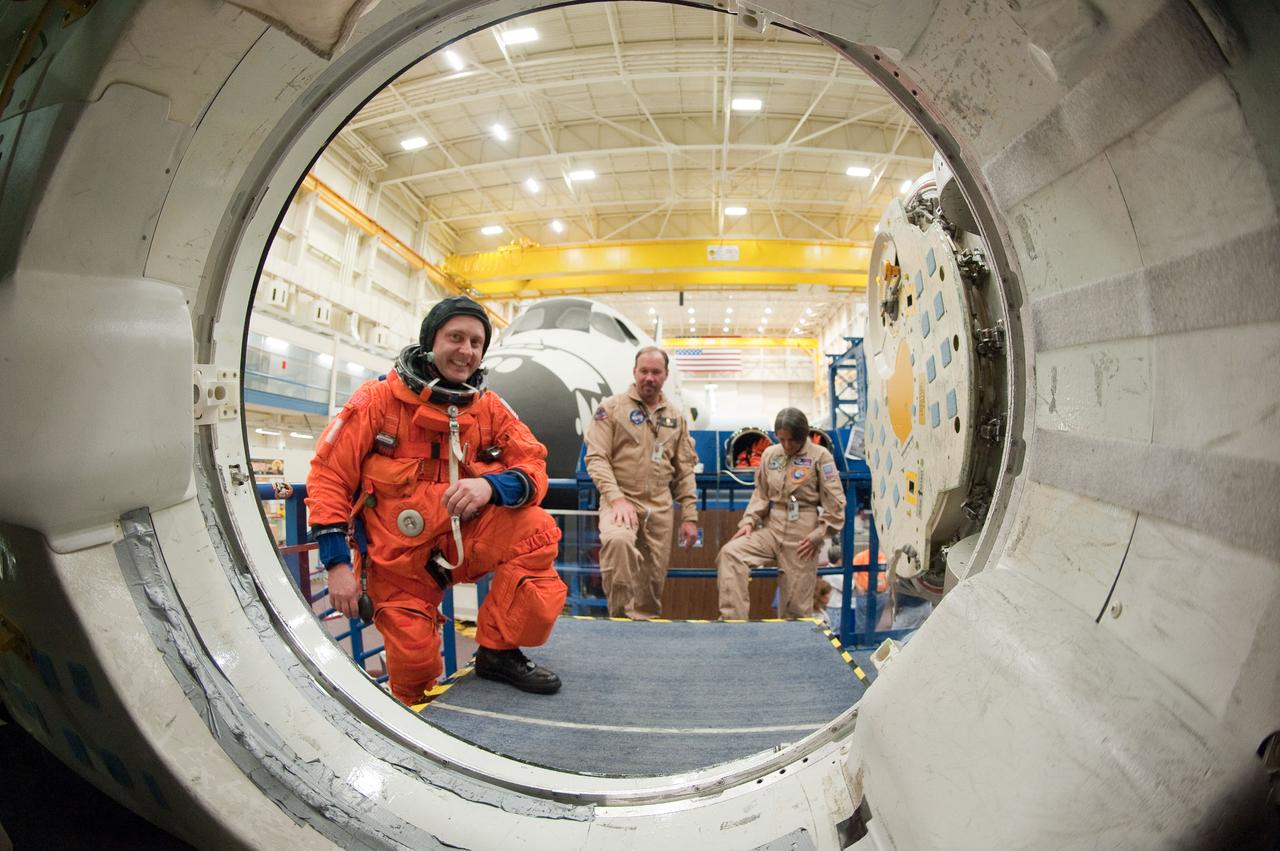JSC2011-E-026940 (11 March 2011) --- NASA astronaut Michael Fincke, STS-134 mission specialist, attired in a training version of his shuttle launch and entry suit, is pictured during an ingress/egress training session in a shuttle mock-up in the Space Vehicle Mock-up Facility at NASA's Johnson Space Center. Also pictured in the background are suit technicians Drew Billingsley and Tony Cost-Davis. Photo credit: NASA or National Aeronautics and Space Administration
