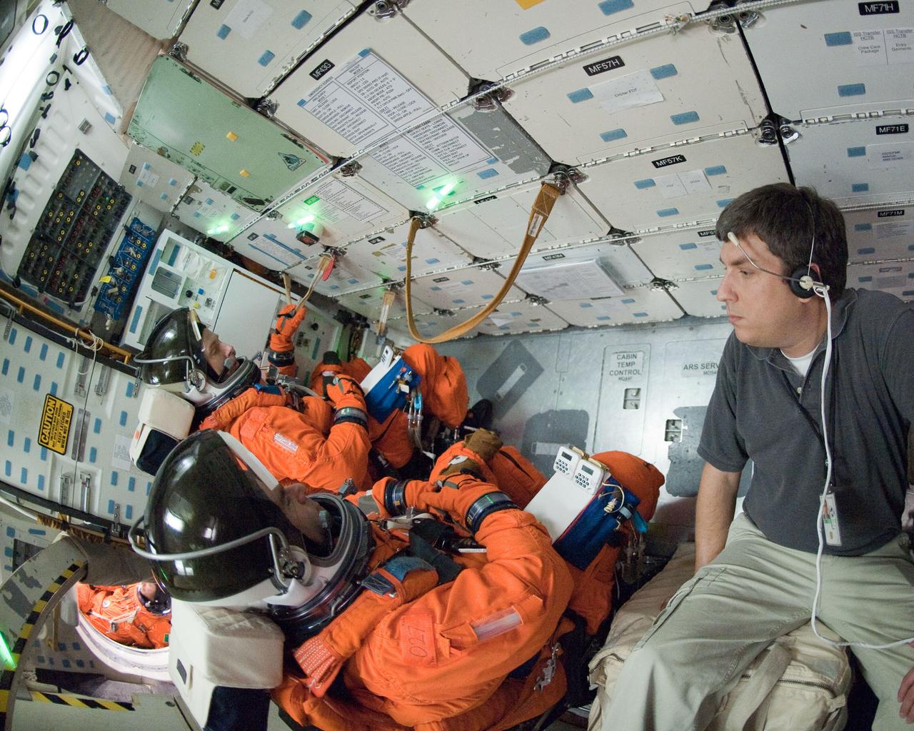 JSC2011-E-026947 (11 March 2011) --- Attired in training versions of their shuttle launch and entry suits, NASA astronaut Greg Chamitoff (foreground) and Andrew Feustel, both STS-134 mission specialists, participate in an ingress/egress training session in a shuttle mock-up in the Space Vehicle Mock-up Facility at NASA's Johnson Space Center. Photo credit: NASA or National Aeronautics and Space Administration