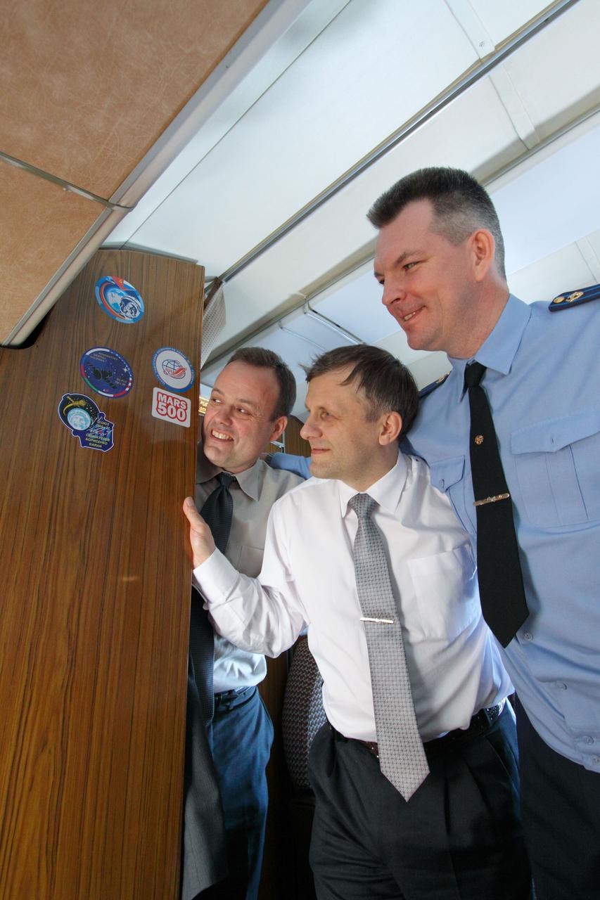 Expedition 27 Flight Engineer Ron Garan of NASA (left), Flight Engineer Andrey Borisenko (center) and Soyuz Commander Alexander Samokutyaev (right) admire their Soyuz crew patch aboard a Gagarin Cosmonaut Training Center plane as they flew from Star City, Russia to the Baikonur Cosmodrome in Kazakhstan March 21, 2011. There, they will complete training for their launch April 5 (April 4, U.S. time) on the Soyuz TMA-21 spacecraft to the International Space Station. Credit: NASA/Victor Zelentsov