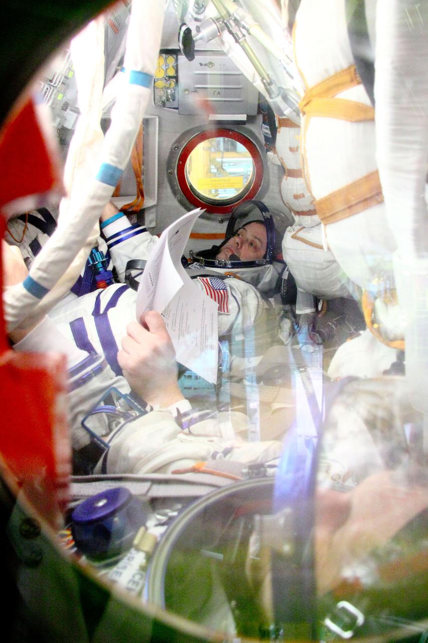 Seated in the right seat of the descent module of the Soyuz TMA-21 spacecraft, Expedition 27 Flight Engineer Ron Garan of NASA runs through a checklist of procedures during a dress rehearsal of launch activities at the Baikonur Cosmodrome in Kazakhstan March 22, 2011. Garan, Soyuz Commander Alexander Samokutyaev (center) and Flight Engineer Andrey Borisenko are scheduled to launch April 5 (April 4, U.S. time) in the Soyuz, which has been dubbed “Gagarin” and which bears the likeness of cosmonaut Yuri Gagarin, the first human in space. The launch will occur just one week shy of the 50th anniversary of Gagarin’s historic journey into space from the same launch pad that the Expedition 27 crew will begin their mission from. NASA/Victor Zelentsov
