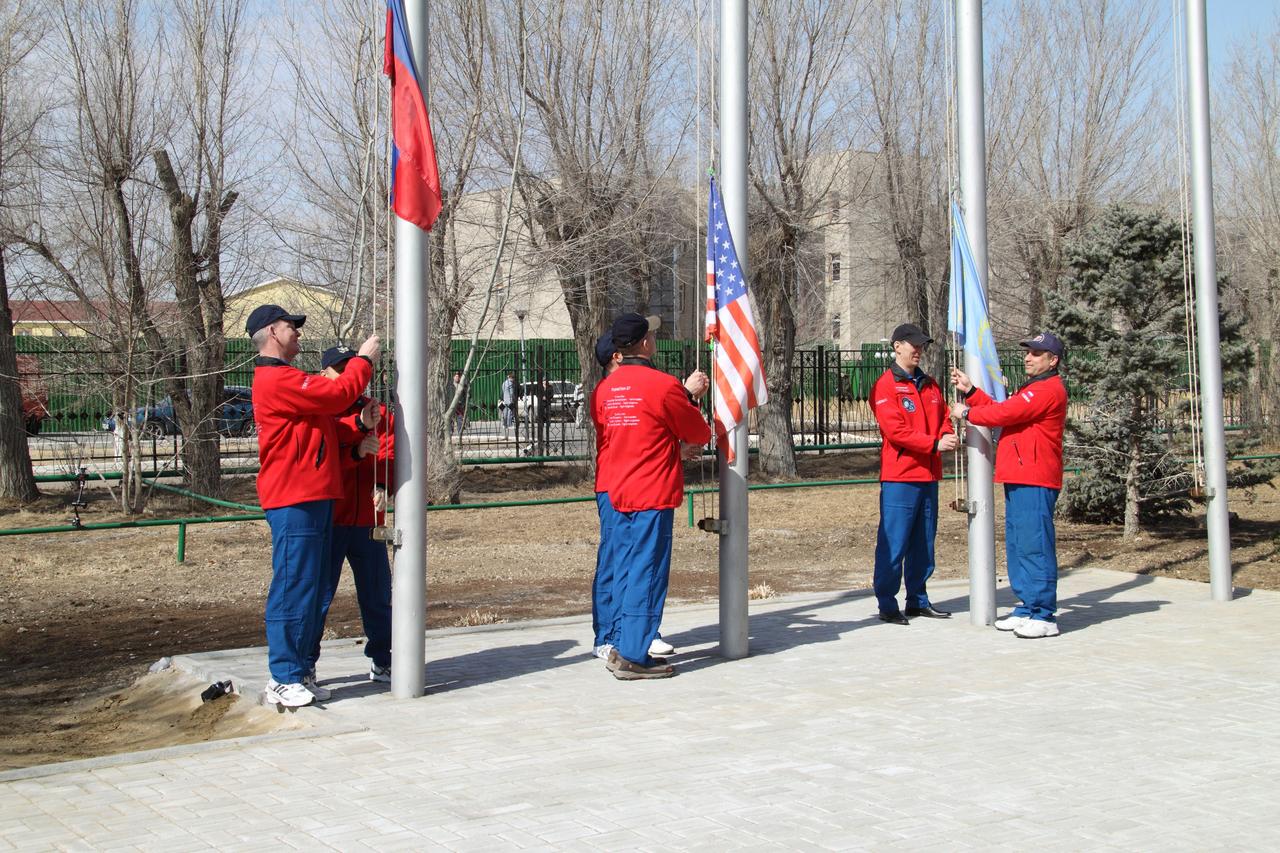 Outside their Cosmonaut Hotel crew quarters in Baikonur, Kazakhstan, the Expedition 27 prime and backup crewmembers conducted the ceremonial raising of the Russian, U.S. and Kazakh flags on March 23, 2011 as part of their traditional pre-launch activities. Seen from left to right are prime Russian crewmembers Alexander Samokutyaev and Andrey Borisenko, prime NASA Flight Engineer Ron Garan (center) and his backup, Dan Burbank and backup Russian crewmembers Anton Shkaplerov and Anatoly Ivanishin. Garan, Samokutyaev and Borisenko are scheduled to launch on April 5 (April 4, U.S. time) from the Baikonur Cosmodrome in Kazakhstan to the International Space Station on the Soyuz TMA-21 spacecraft that has been dubbed “Gagarin”, in honor of the 50th anniversary of the launch of Yuri Gagarin on April 12, 1961 to become the first human to fly in space. Credit: NASA/Victor Zelentsov