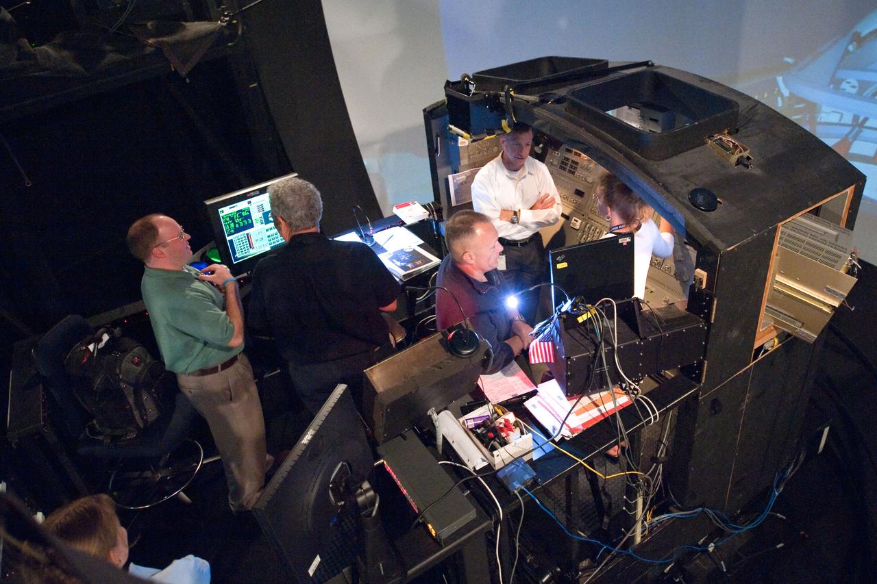 JSC2011-E-028130 (23 March 2011) --- NASA astronauts Chris Ferguson (right background), STS-135 commander; Doug Hurley (center), pilot; and Sandy Magnus, mission specialist, participate in an exercise in the systems engineering simulator in the Avionics Systems Laboratory at NASA's Johnson Space Center. The facility includes moving scenes of full-sized International Space Station components over a simulated Earth. Photo credit: NASA or National Aeronautics and Space Administration