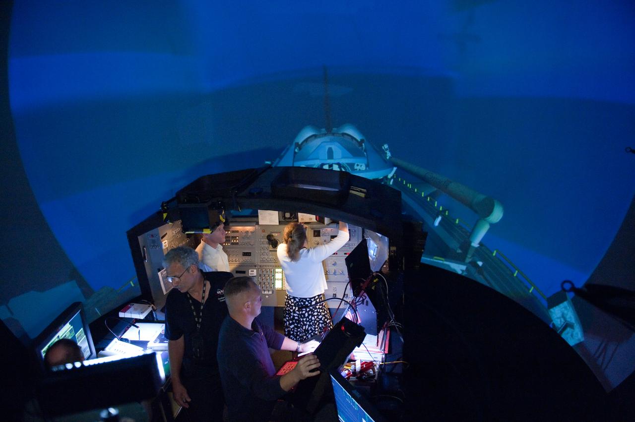 JSC2011-E-028137 (23 March 2011) --- NASA astronauts Chris Ferguson (left background), STS-135 commander; Doug Hurley (foreground), pilot; and Sandy Magnus, mission specialist, participate in an exercise in the systems engineering simulator in the Avionics Systems Laboratory at NASA's Johnson Space Center. The facility includes moving scenes of full-sized International Space Station components over a simulated Earth. Photo credit: NASA or National Aeronautics and Space Administration