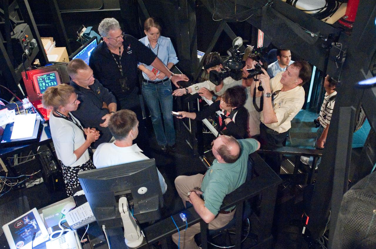 JSC2011-E-028144 (23 March 2011) --- NASA astronauts Chris Ferguson (left foreground), STS-135 commander; Doug Hurley (left background), pilot; and Sandy Magnus (left), mission specialist, speak with news media representatives during an exercise in the systems engineering simulator in the Avionics Systems Laboratory at NASA's Johnson Space Center. The facility includes moving scenes of full-sized International Space Station components over a simulated Earth. Photo credit: NASA or National Aeronautics and Space Administration