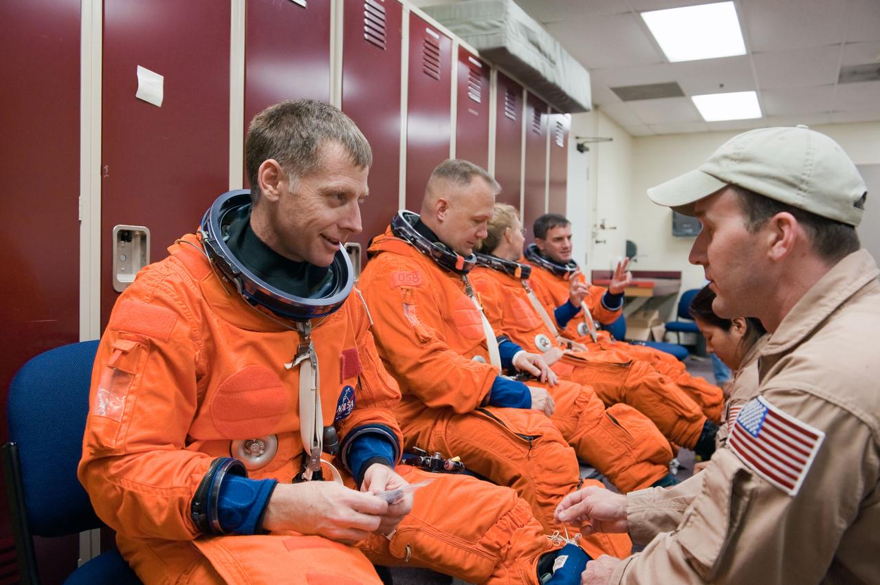 JSC2011-E-028473 (24 March 2011) --- NASA astronauts Chris Ferguson (left foreground), STS-135 commander; Doug Hurley, pilot; Sandy Magnus and Rex Walheim, both mission specialists, don training versions of their shuttle launch and entry suits in preparation for a training session in the Full Fuselage Trainer (FFT) in the Space Vehicle Mock-up Facility at NASA's Johnson Space Center. Suit technician Jeremy Spruell assisted Ferguson. Photo credit: NASA or National Aeronautics and Space Administration