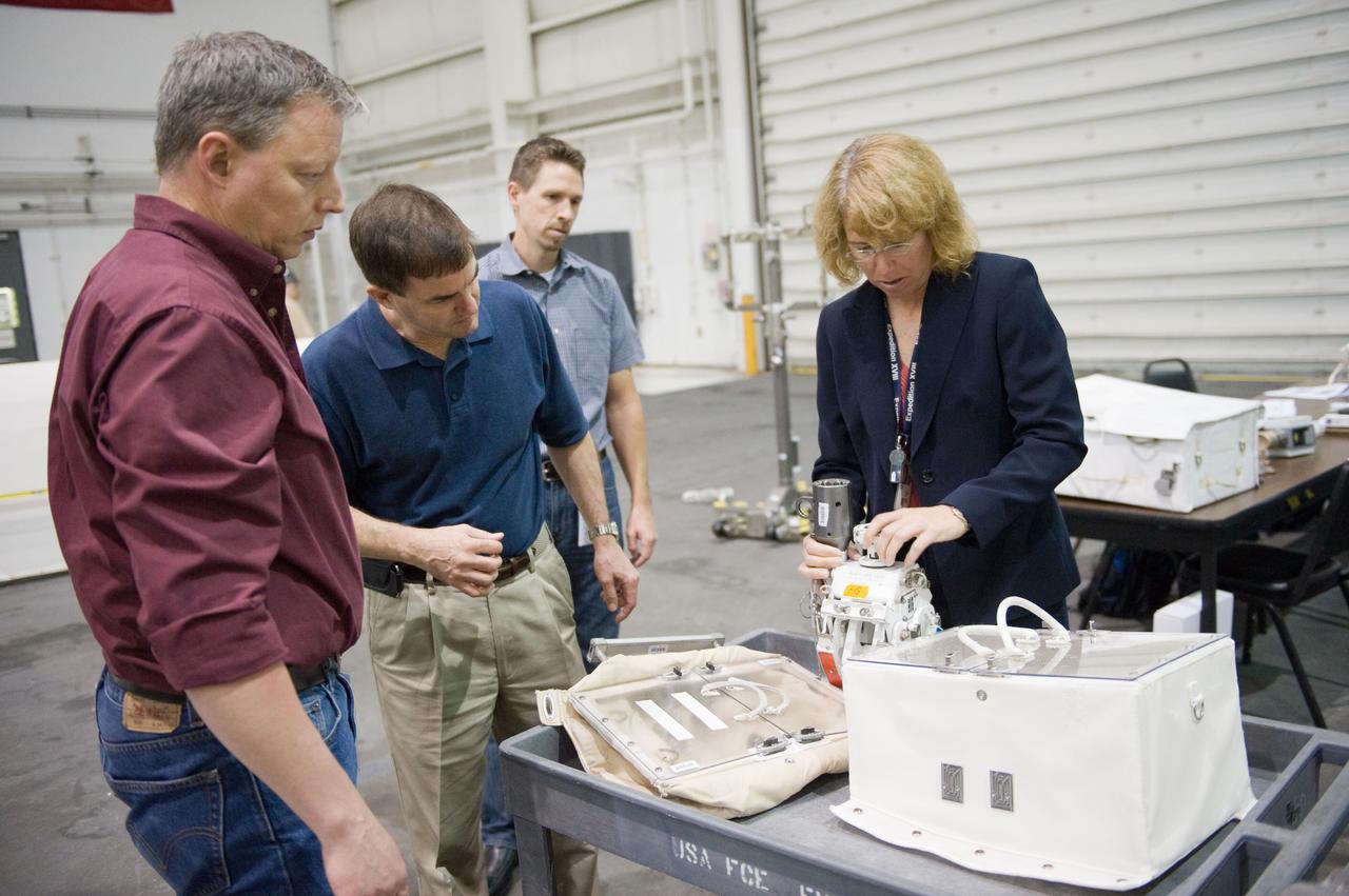 JSC2011-E-029042 (21 March 2011) --- NASA astronauts Rex Walheim (second left) and Sandy Magnus, both STS-135 mission specialists, participate in an extravehicular activity (EVA) hardware training session in the Neutral Buoyancy Laboratory (NBL) near NASA's Johnson Space Center. EVA instructors John Ray (left foreground) and Art Thomason assisted Walheim and Magnus. STS-135 is planned to be the final mission of the space shuttle program. Photo credit: NASA or National Aeronautics and Space Administration
