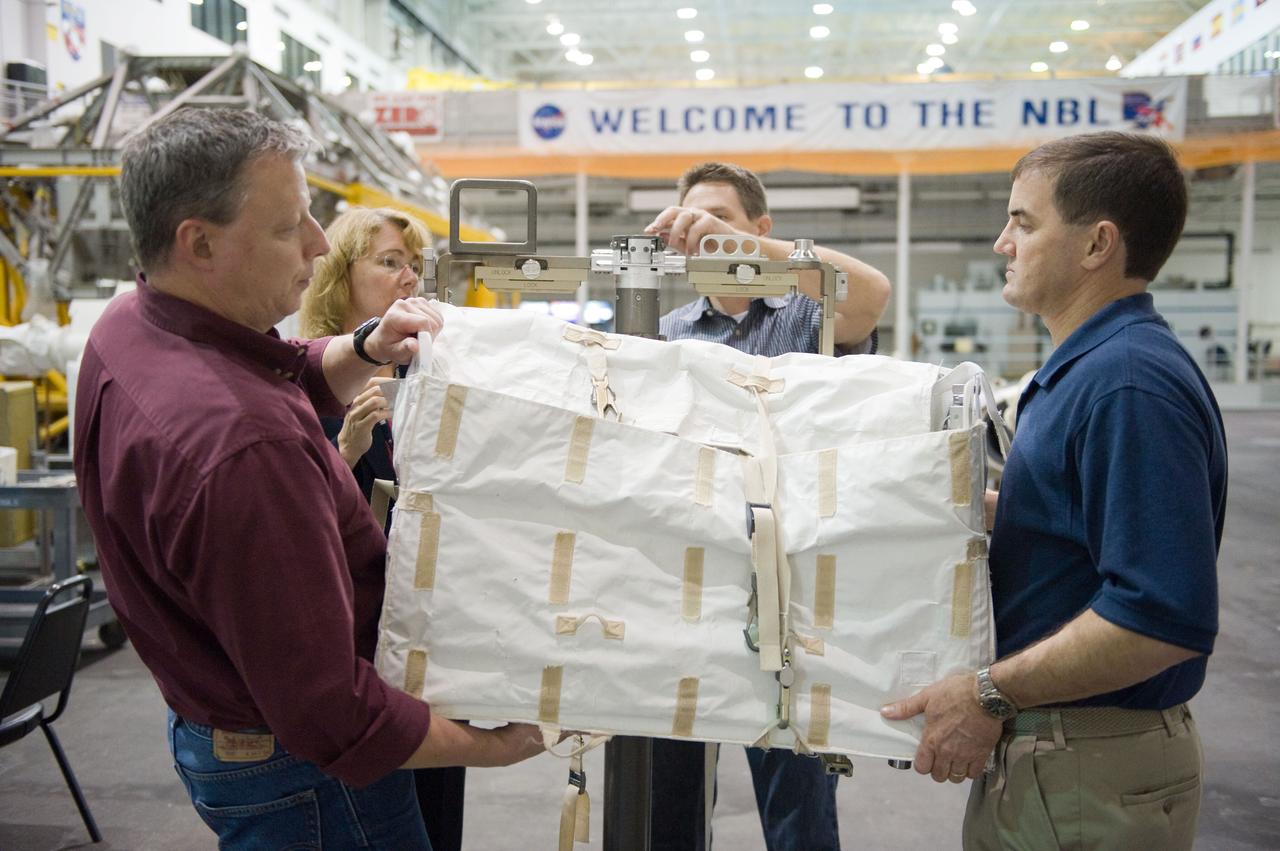 JSC2011-E-029056 (21 March 2011) --- NASA astronauts Rex Walheim (right) and Sandy Magnus, both STS-135 mission specialists, participate in an extravehicular activity (EVA) hardware training session in the Neutral Buoyancy Laboratory (NBL) near NASA's Johnson Space Center. EVA instructors John Ray (left foreground) and Art Thomason assisted Walheim and Magnus. STS-135 is planned to be the final mission of the space shuttle program. Photo credit: NASA or National Aeronautics and Space Administration