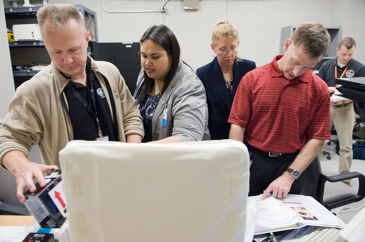 JSC2011-E-029084 (21 March 2011) --- NASA astronauts Chris Ferguson (right), STS-135 commander; Sandy Magnus (second right), mission specialist; and Doug Hurley, pilot, participate in a training session in the Neutral Buoyancy Laboratory (NBL) near NASA's Johnson Space Center. Crew instructors assisted the crew members. STS-135 is planned to be the final mission of the space shuttle program. Photo credit: NASA or National Aeronautics and Space Administration