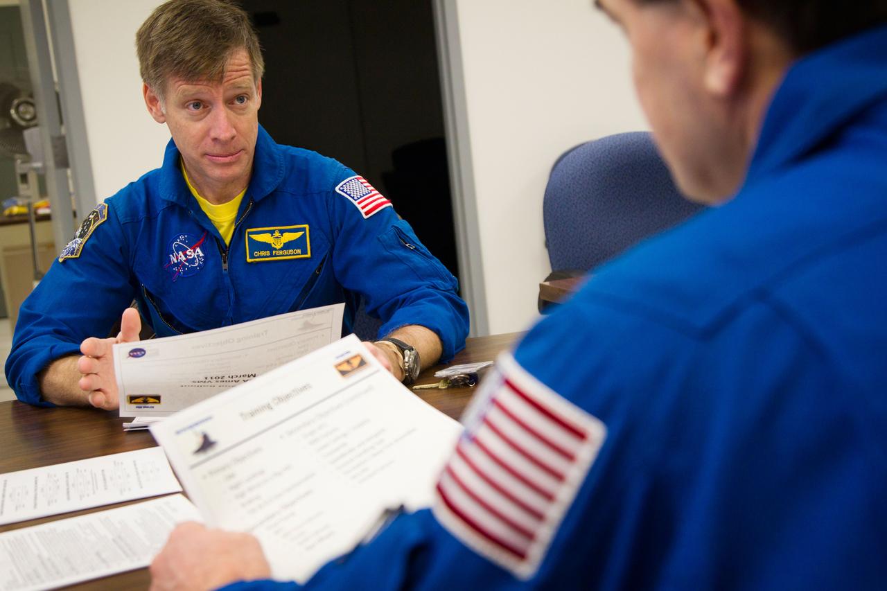 JSC2011-E-040193 (2 March 2011) --- NASA astronaut Chris Ferguson (left), STS-135 commander, confers with astronaut Rex Walheim, mission specialist, as the Atlantis crew participates in a briefing before a training session in the Vertical Motion Simulator (VMS) at NASA's Ames Research Center in Mountain View, Calif. March 2, 2011.  Photo credit: NASA Photo/Houston Chronicle, Smiley N. Pool
