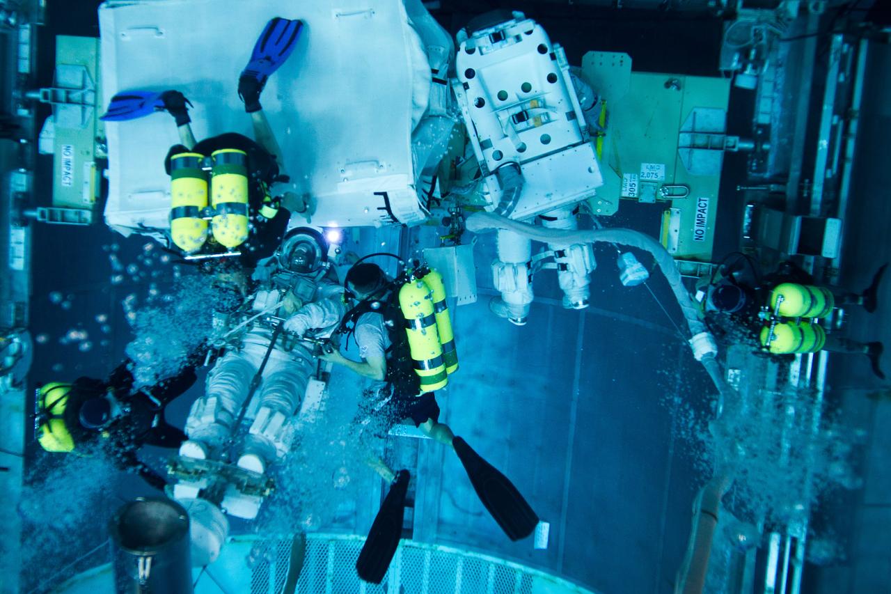 JSC2011-E-040217 (10 March 2011) --- NASA astronaut Rex Walheim, STS-135 mission specialist, is aided by divers as he works with astronaut Mike Fossum in a mock-up of the space shuttle's payload bay as the crew of STS-135 trains for a spacewalk in the Neutral Buoyancy Laboratory near NASA?s Johnson Space Center on March 10, 2011. Photo credit: NASA Photo/Houston Chronicle, Smiley N. Pool