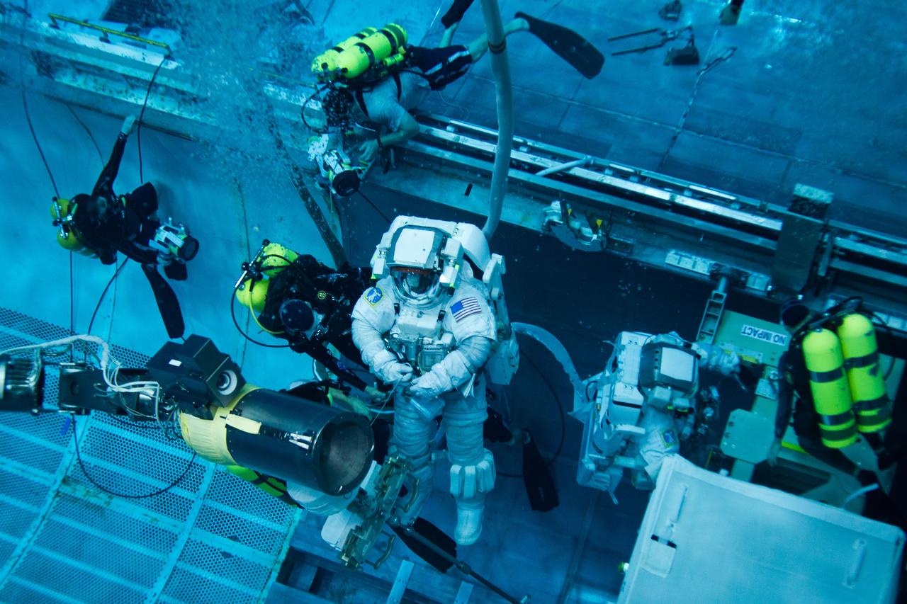 JSC2011-E-040219 (10 March 2011) --- NASA astronaut Rex Walheim (left), STS-135 mission specialist, and astronaut Mike Fossum are aided by divers as they work in a mock-up of the space shuttle's payload bay as the crew of STS-135 trains for a spacewalk in the Neutral Buoyancy Laboratory near NASA?s Johnson Space Center on March 10, 2011. Photo credit: NASA Photo/Houston Chronicle, Smiley N. Pool