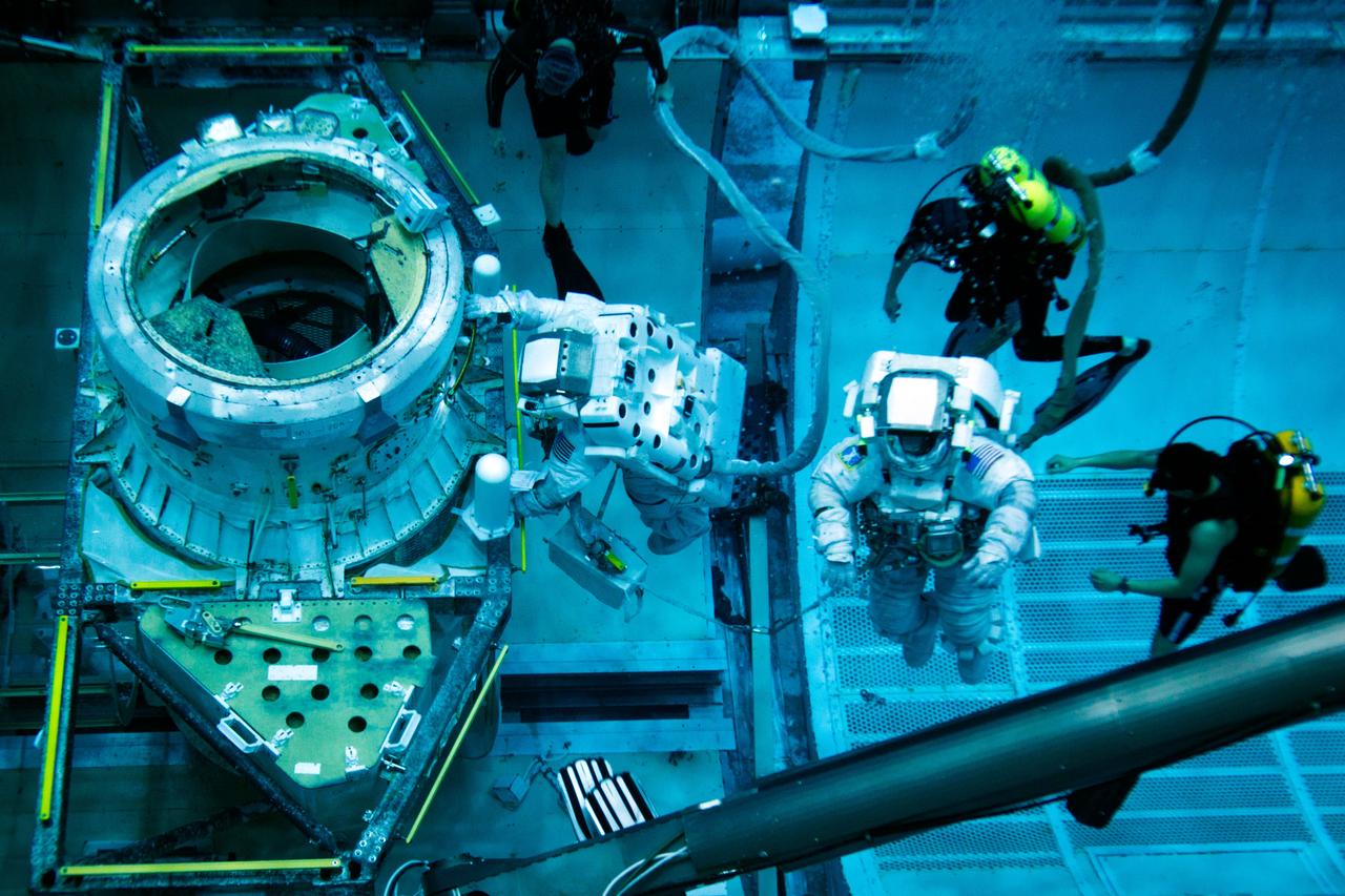 JSC2011-E-040220 (10 March 2011) --- NASA astronaut Rex Walheim (left), STS-135 mission specialist, and astronaut Mike Fossum are aided by divers as they work in a mock-up of the space shuttle's payload bay as the crew of STS-135 trains for a spacewalk in the Neutral Buoyancy Laboratory near NASA?s Johnson Space Center on March 10, 2011. Photo credit: NASA Photo/Houston Chronicle, Smiley N. Pool