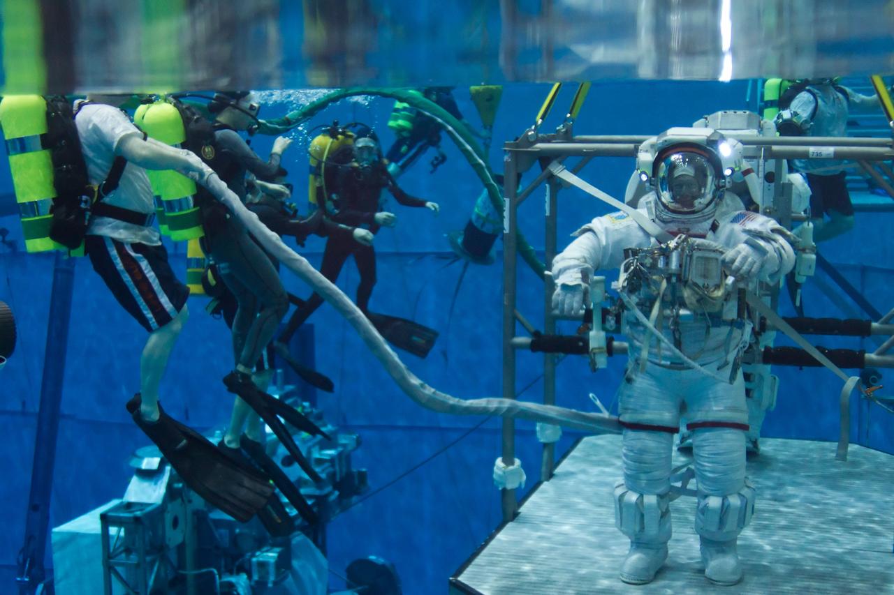 JSC2011-E-040221 (10 March 2011) --- NASA astronaut Mike Fossum is aided by divers as he trains for a spacewalk with astronaut Rex Walheim, STS-135 mission specialist, in the Neutral Buoyancy Laboratory near NASA?s Johnson Space Center on March 10, 2011. Photo credit: NASA Photo/Houston Chronicle, Smiley N. Pool