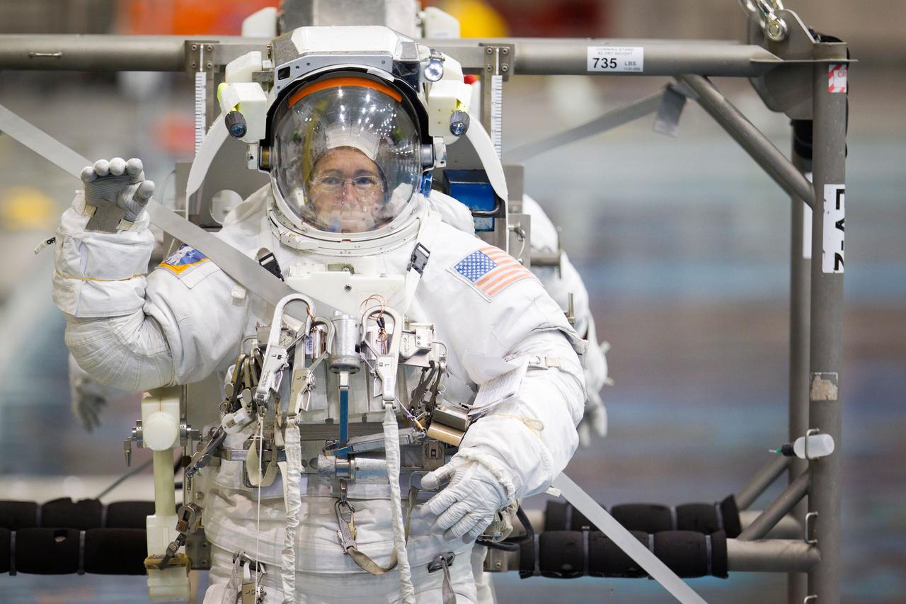 NASA astronaut Sandy Magnus waves as she is lowered into the water to train for spacewalk  in the Neutral Buoyancy Laboratory (NBL) on Tuesday, March 22, 2011, in Houston.  ( NASA Photo / Houston Chronicle, Smiley N. Pool )