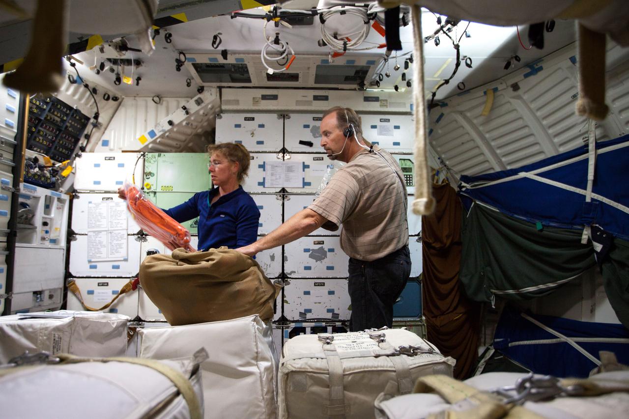 JSC2011-E-040278 (24 March 2011) --- Rob Tomaro, crew systems instructor, works with NASA astronaut Sandy Magnus, STS-135 mission specialist, on the middeck of the Full-Fuselage Trainer during a post-insertion training session in the Space Vehicle Mock-up Facility at NASA's Johnson Space Center on March 24, 2011. Photo credit: NASA Photo/Houston Chronicle, Smiley N. Pool