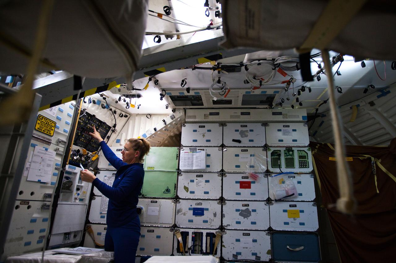 JSC2011-E-040281 (24 March 2011) --- NASA astronaut Sandy Magnus, STS-135 mission specialist, works on the middeck of the Full-Fuselage Trainer during a post-insertion training session in the Space Vehicle Mock-up Facility at NASA's Johnson Space Center on March 24, 2011. Photo credit: NASA Photo/Houston Chronicle, Smiley N. Pool