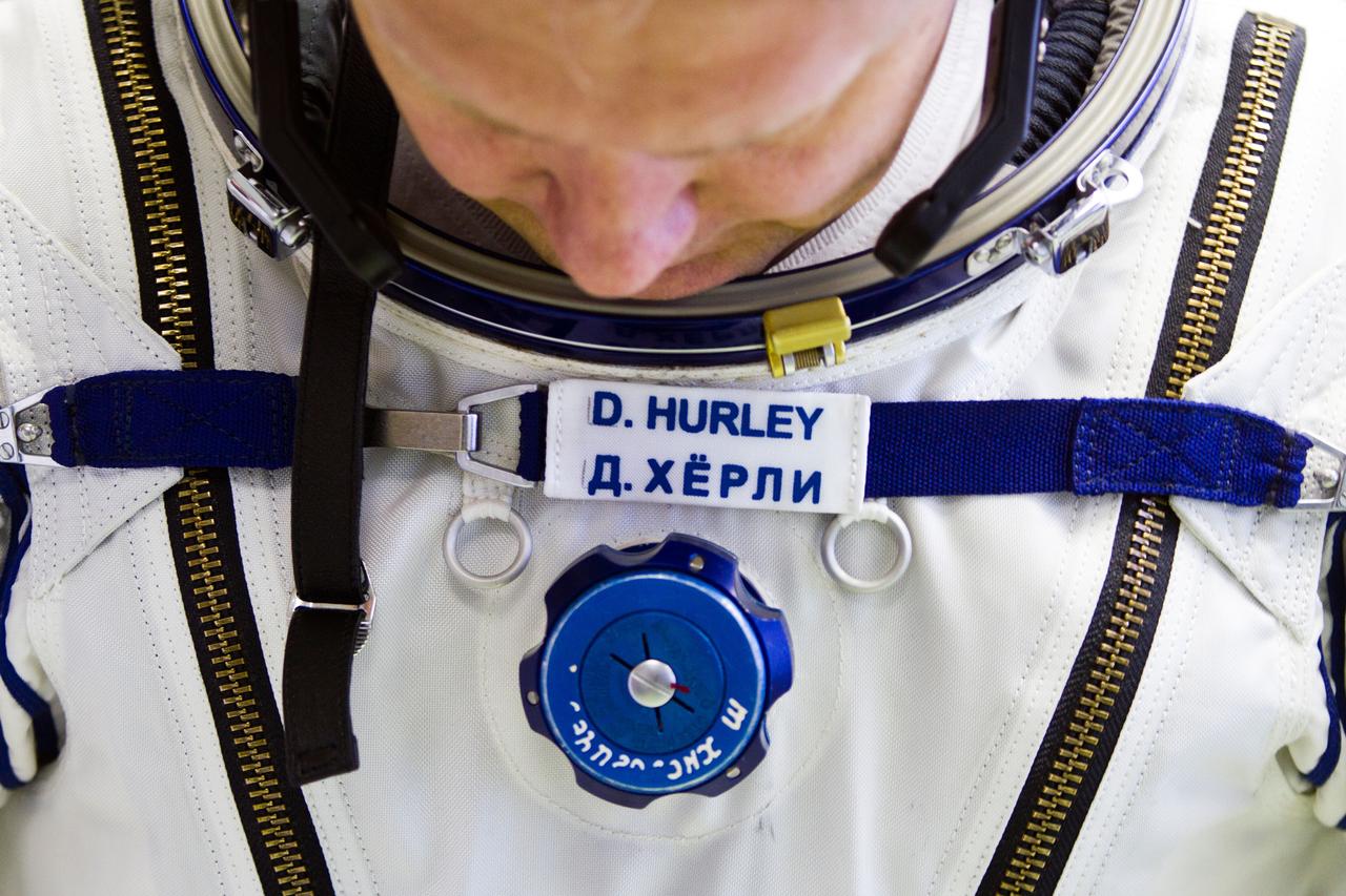 JSC2011-E-040291 (28 March 2011) --- NASA astronaut Doug Hurley, STS-135 pilot, dons a Sokol spacesuit March 28, 2011, at the Zvezda facility in Moscow. Hurley's name appears first in English and then in Russian on his suit. The order is reversed on the suits of Russian cosmonauts. Photo credit: NASA Photo/Houston Chronicle, Smiley N. Pool