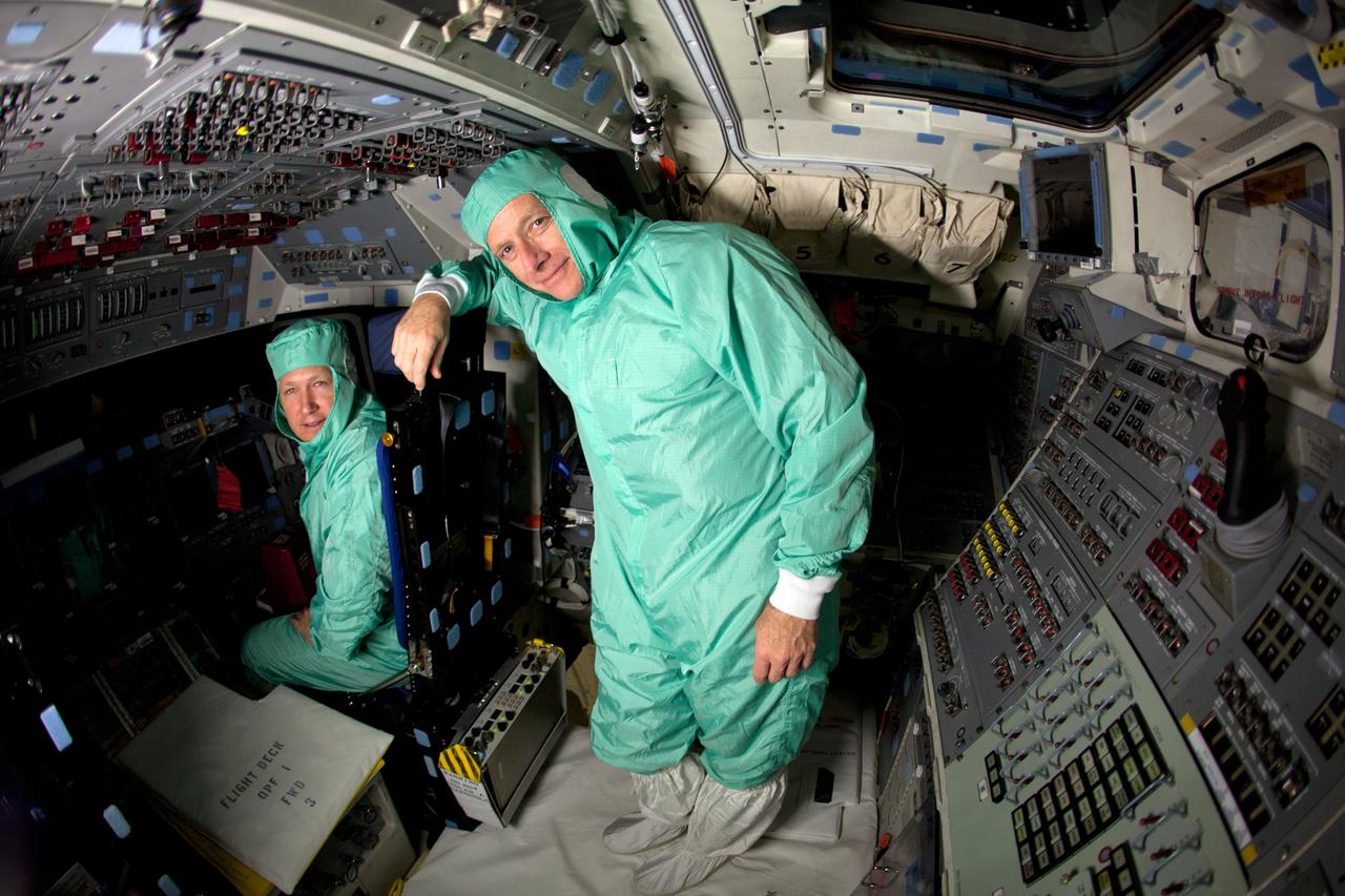 JSC2011-E-040357 (7 April 2011) --- NASA astronauts Chris Ferguson (right), STS-135 commander; and Doug Hurley, pilot, pose for a photo on the cockpit of the space shuttle Atlantis during the STS-135 Crew Equipment Interface Test (CEIT) in the Orbiter Processing Facility at NASA?s Kennedy Space Center, Florida on April 7, 2011. Photo credit: NASA Photo/Houston Chronicle, Smiley N. Pool