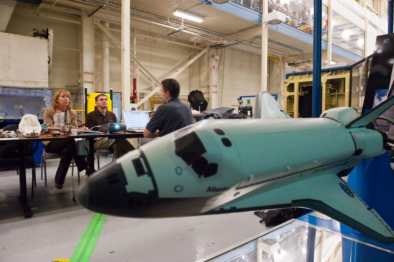 JSC2011-E-043869 (29 April 2011) --- NASA astronauts Sandy Magnus and Rex Walheim, both STS-135 mission specialists, participate in an EVA Thermal Protection System (TPS) overview training session in the TPS/Precision Air Bearing Facility in the Space Vehicle Mock-up Facility at NASA's Johnson Space Center. A model of a space shuttle is in the foreground. Photo credit: NASA