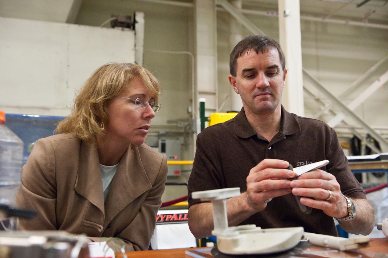 JSC2011-E-043877 (29 April 2011) --- NASA astronauts Sandy Magnus and Rex Walheim, both STS-135 mission specialists, participate in an EVA Thermal Protection System (TPS) overview training session in the TPS/ Precision Air Bearing Facility in the Space Vehicle Mock-up Facility at NASA's Johnson Space Center. Photo credit: NASA