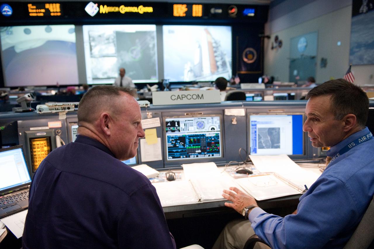 JSC2011-E-044080 (16 May 2011) --- Inside the space shuttle flight control room in Houston?s Mission Control Center two spacecraft communicators discuss the  preparations in both Houston and the launch pad several hundred miles away in Florida for the final launch of Endeavour. Astronauts Barry Wilmore (left) and Lee Archambault staff the CAPCOM console for the prelaunch and launch activities. The shuttle lifted off from Pad 39A at NASA's Kennedy Space Center on time at 8:56 a.m. (EDT) on May 16, 2011.  Photo credit: NASA