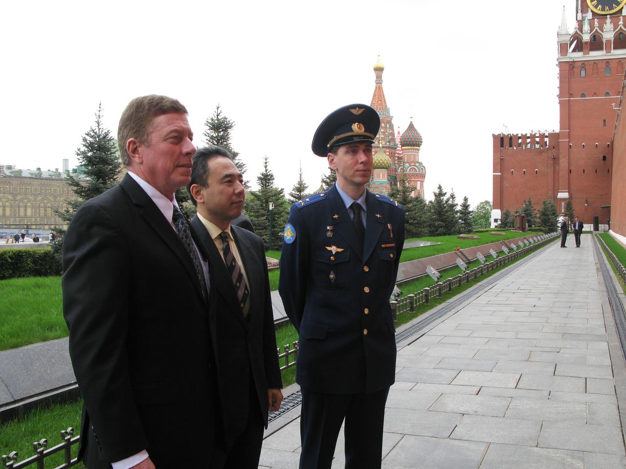 At the Kremlin Wall at Red Square in Moscow, Expedition 28 Flight Engineer Mike Fossum of NASA (left), Flight Engineer Satoshi Furukawa of the Japan Aerospace Exploration Agency (center) and Soyuz Commander Sergei Volkov (right) pose for pictures May 16, 2011 after laying flowers and conducting other traditional activities. The trio will be launched June 8 from the Baikonur Cosmodrome in Kazakhstan on the Soyuz TMA-02M spacecraft to the International Space Station.