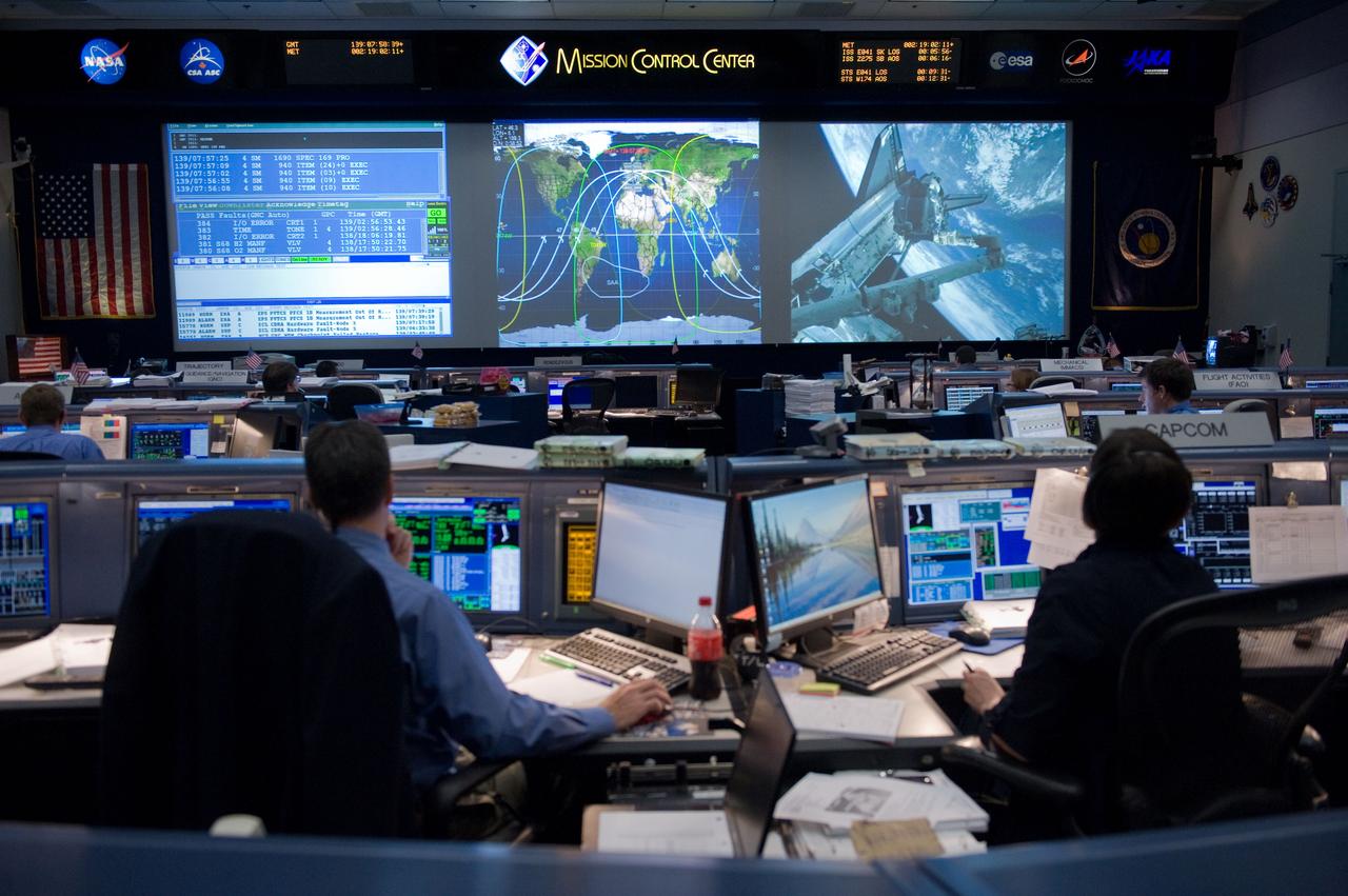 JSC2011-E-046980 (19 May 2011) --- Flight director Gary Horlacher and astronaut Megan McArthur, STS-134 spacecraft communicator (CAPCOM), are pictured at their consoles in the space shuttle flight control room in the Mission Control Center at NASA's Johnson Space Center during flight day four activities. Photo credit: NASA